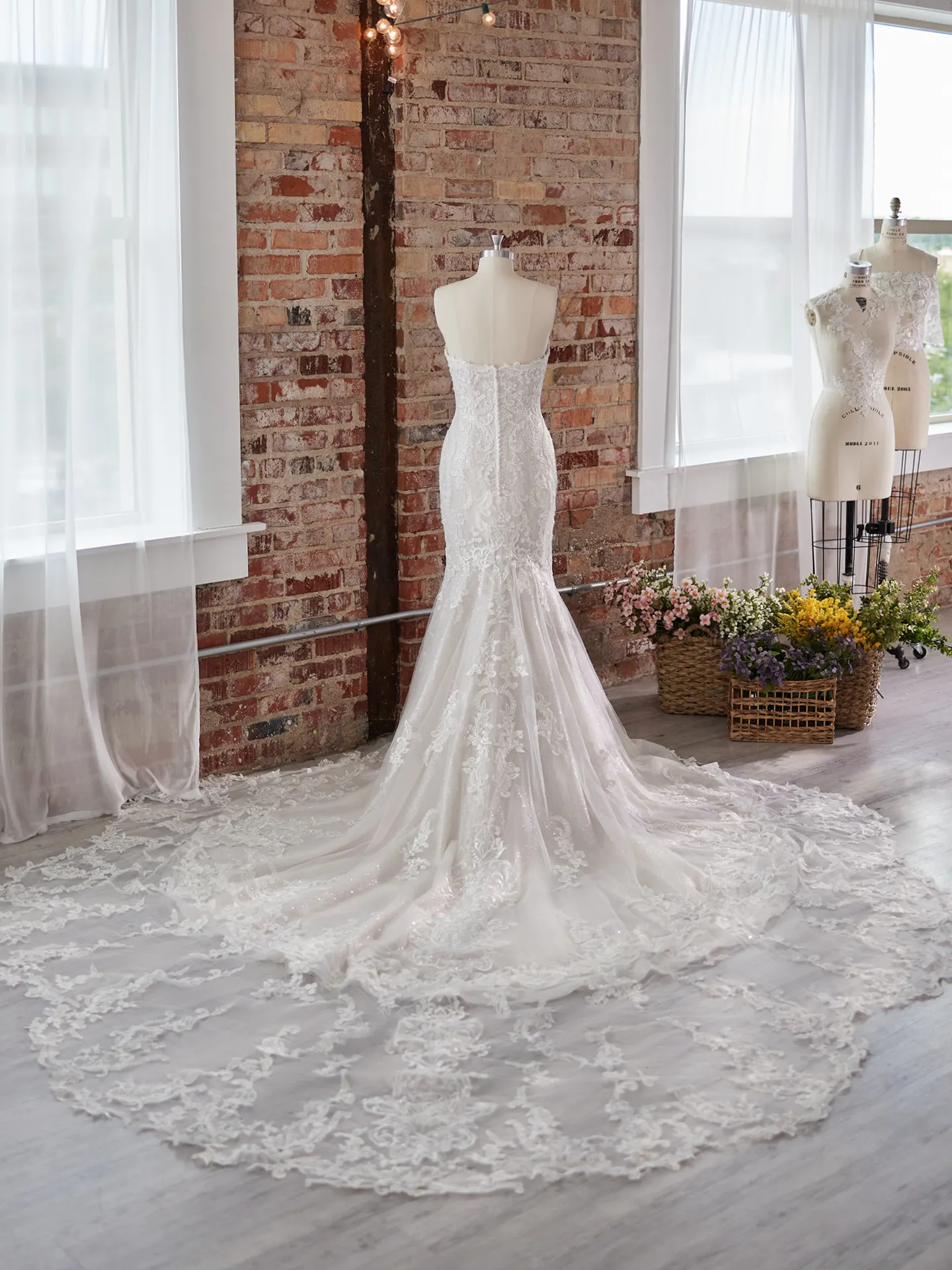 Maggie Sottero Frederique wedding dress back view with lace detail and train.