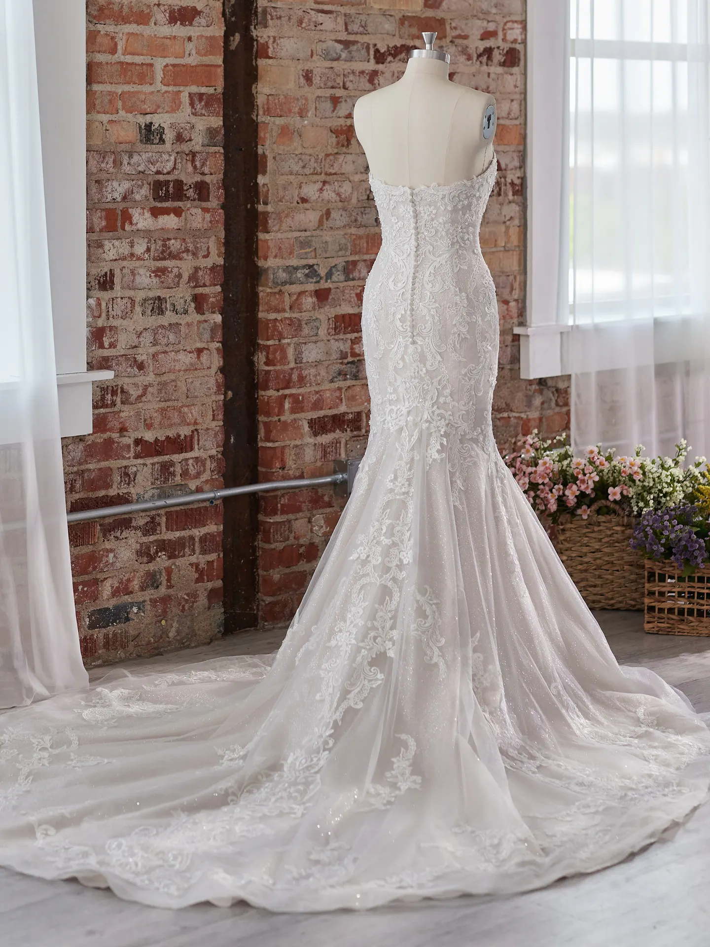 Maggie Sottero Frederique back view bridal dress with lace detailing and train.
