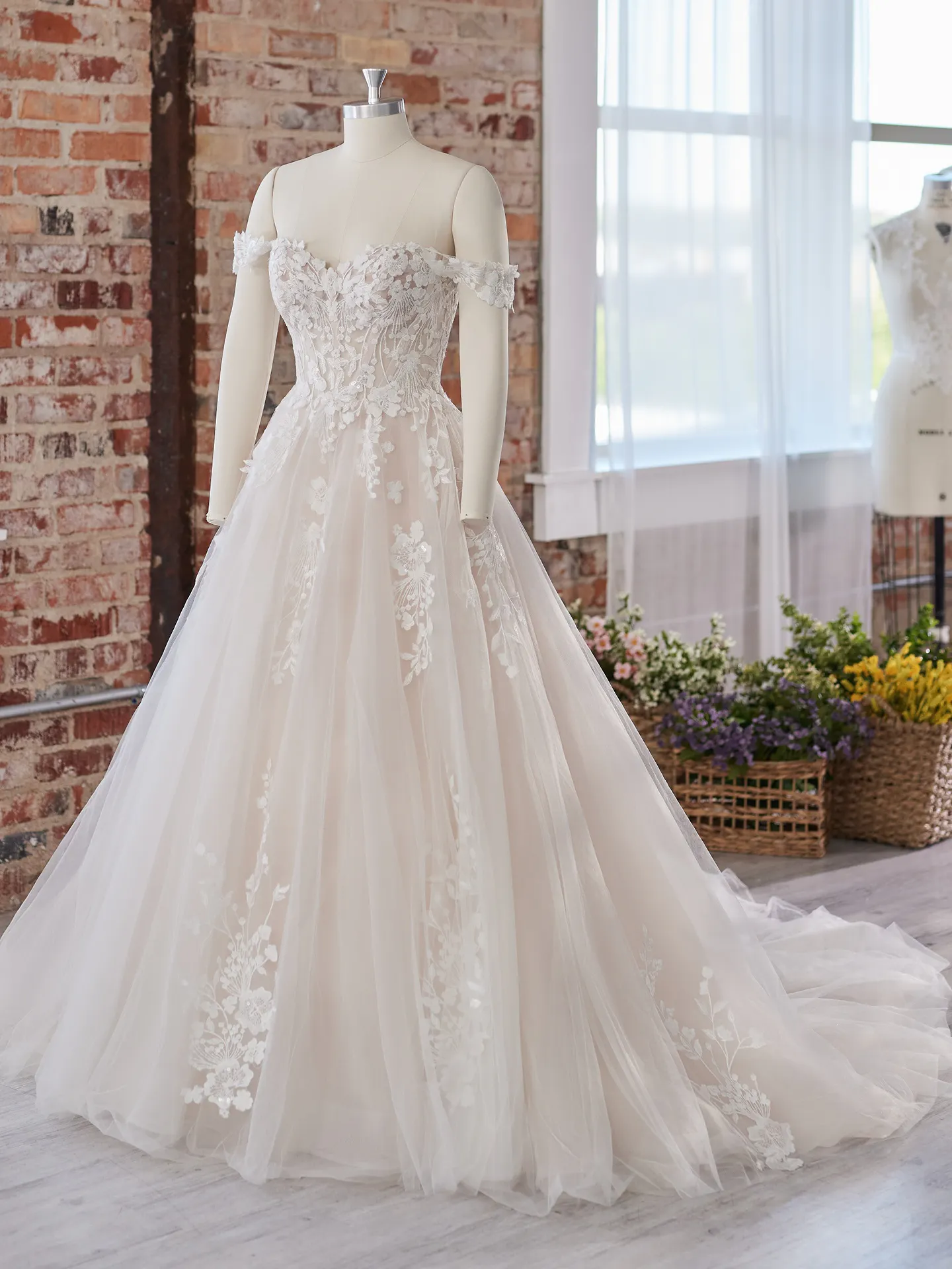 Maggie Sottero Harlem front view off-shoulder fairytale gown with floral lace detailing.