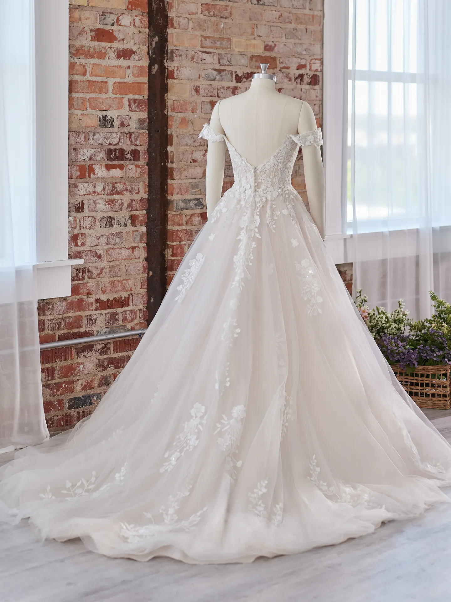 Maggie Sottero Harlem back view off-the-shoulder wedding gown with lace details in rustic setting