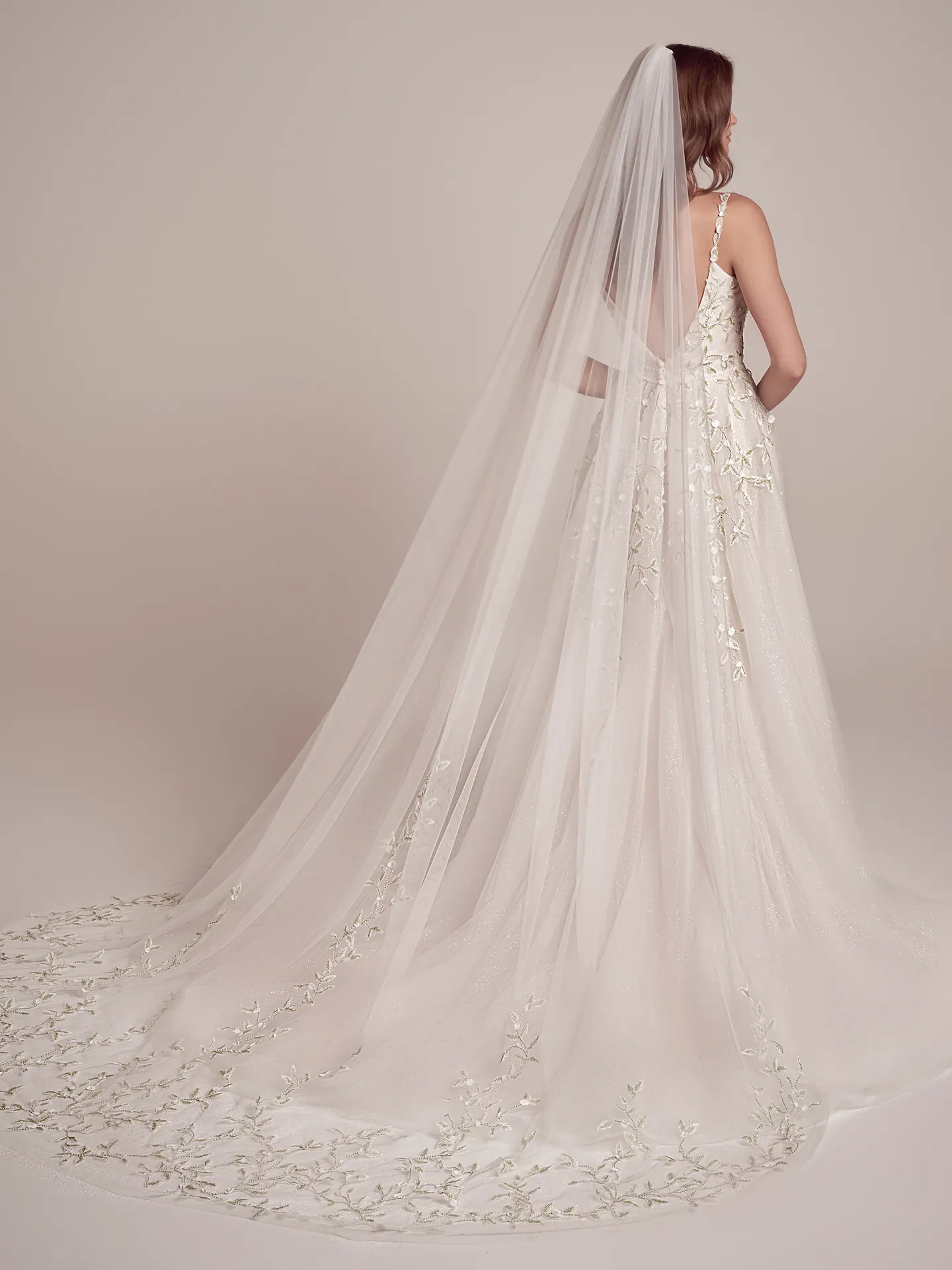 Maggie Sottero beaded bridal dress back view with long veil and floral embroidery.