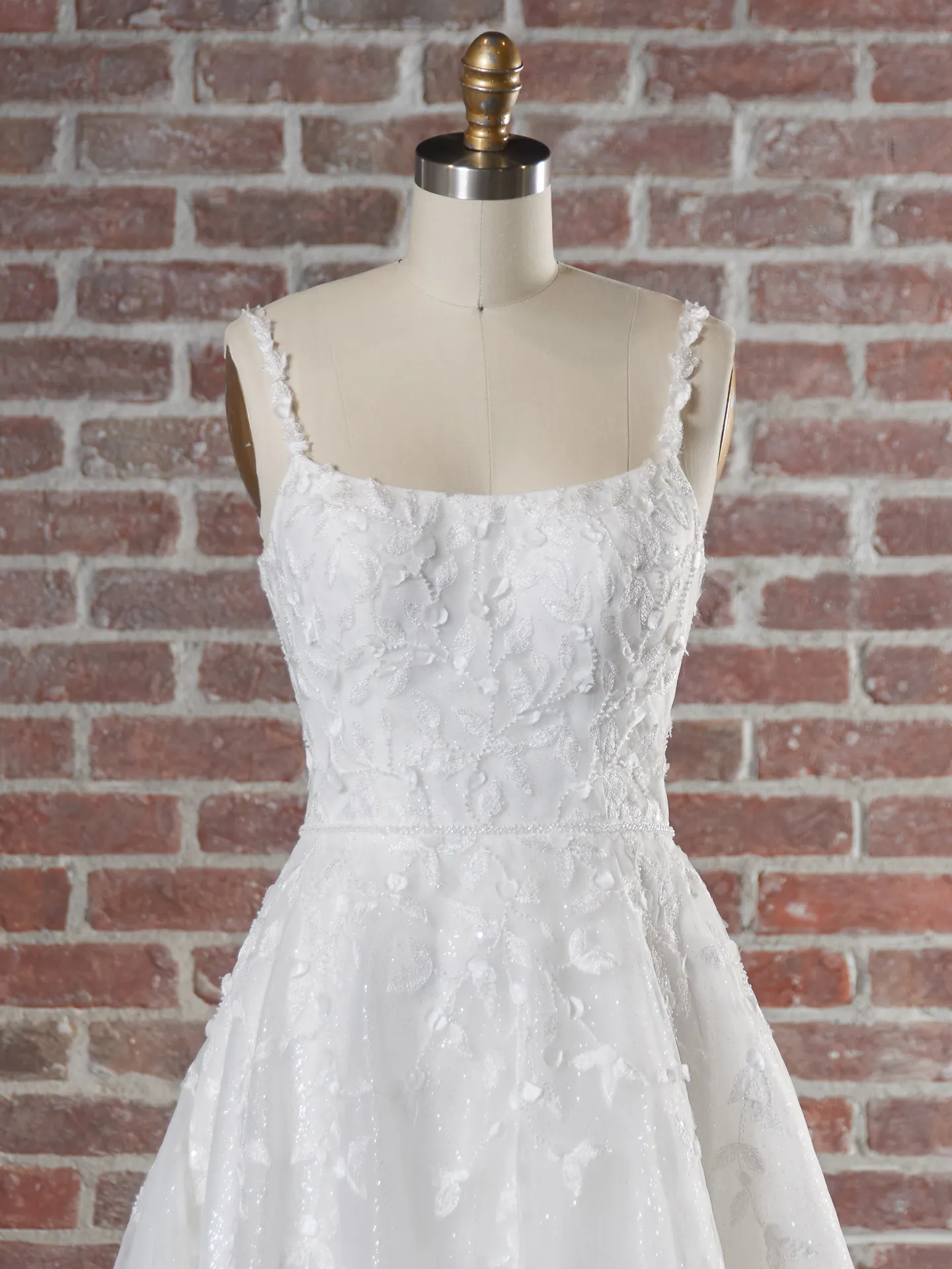 Maggie Sottero dress front view on mannequin against brick wall