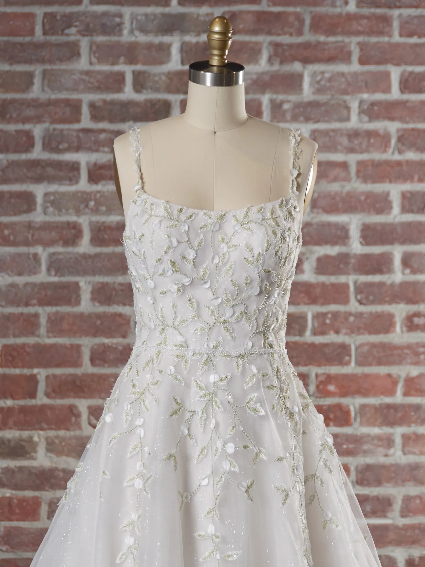 Sottero beaded bridal dress on mannequin, front view with floral details.