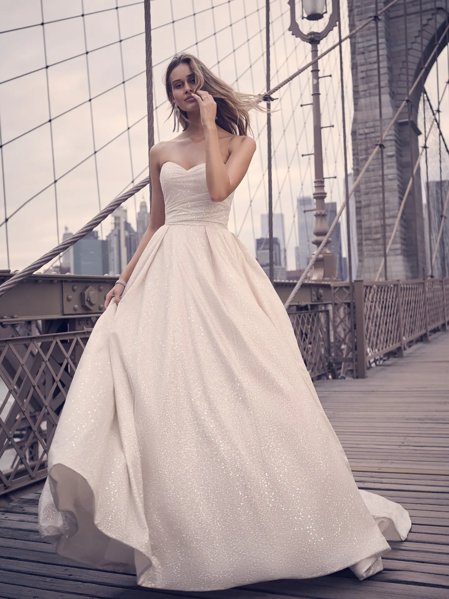Maggie Sottero Anniston shimmery ballgown front view on a bridge