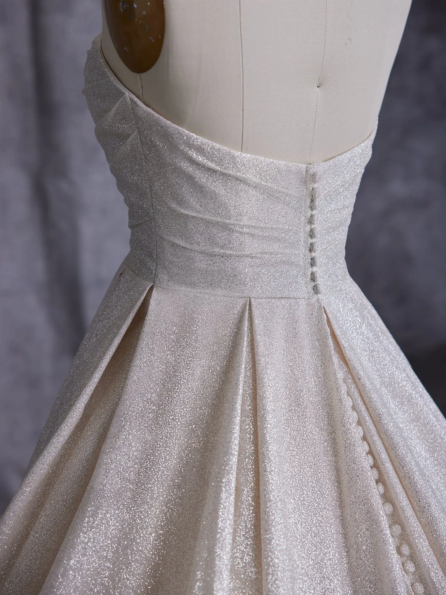 Maggie Sottero Anniston side view shimmery ballgown with buttons.
