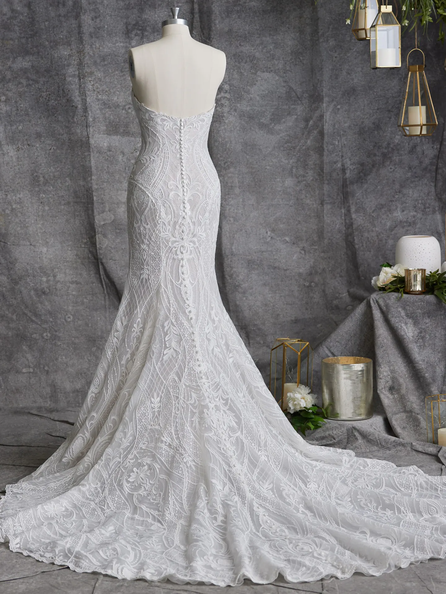 Sottero and Midgley Bronson back view lace fit-and-flare gown on mannequin in elegant setting