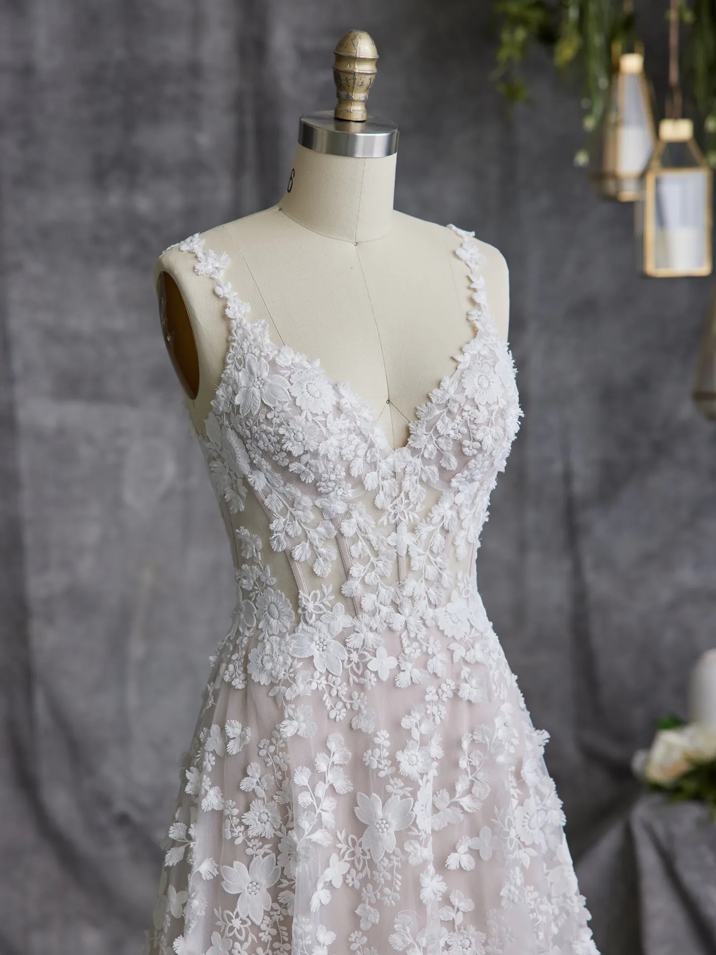 Maggie Sottero Ladonna 3D floral wedding dress close-up on mannequin, front view.