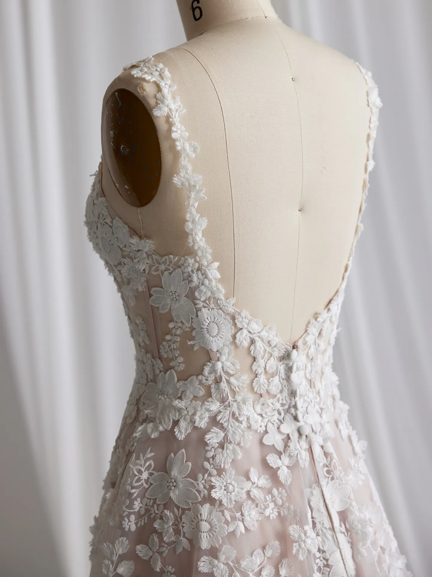 Maggie Sottero Ladonna back view with 3D floral details on a mannequin.