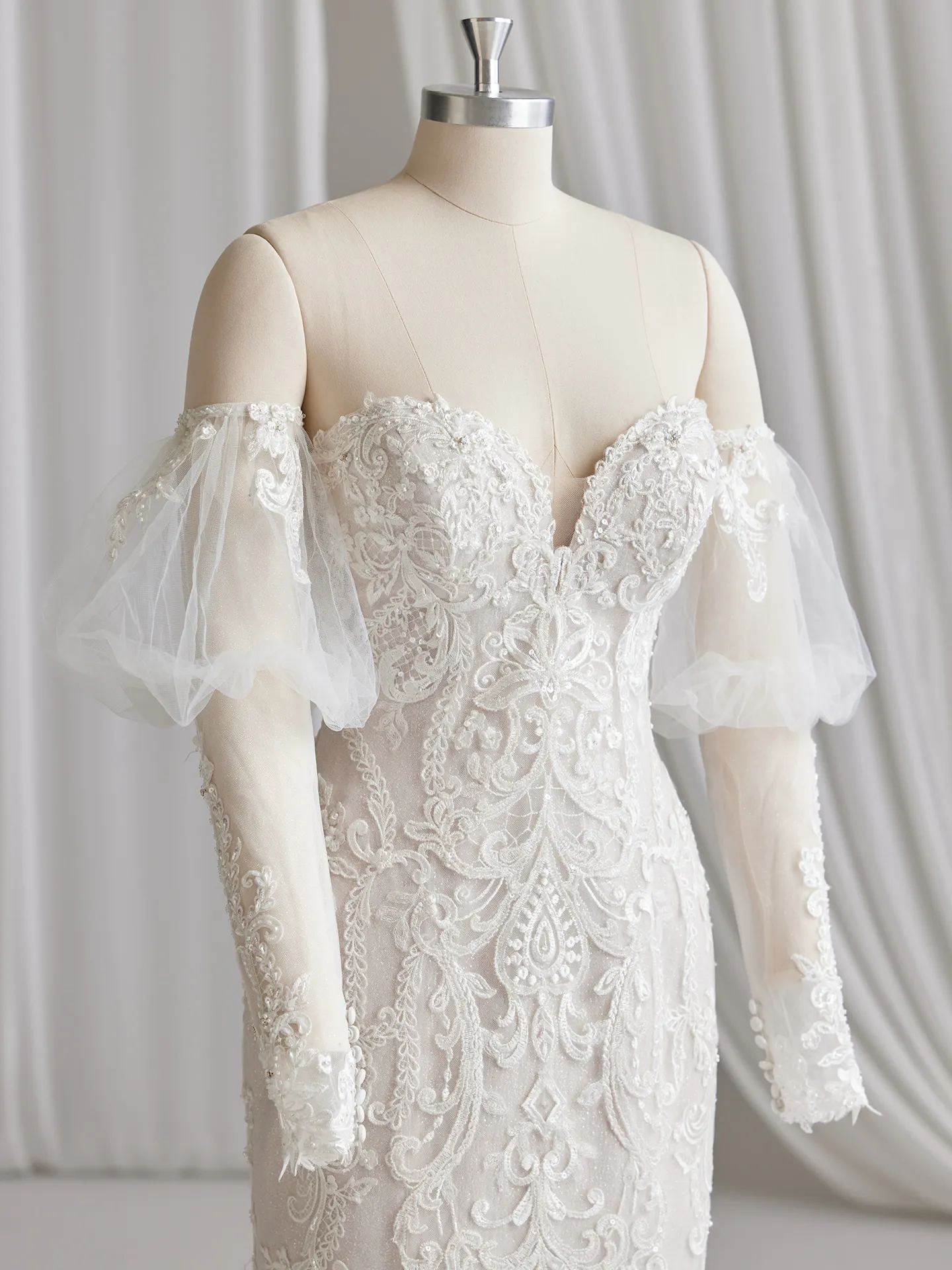 Maggie Sottero Frederique front view off-the-shoulder lace bridal dress detailing on dress form