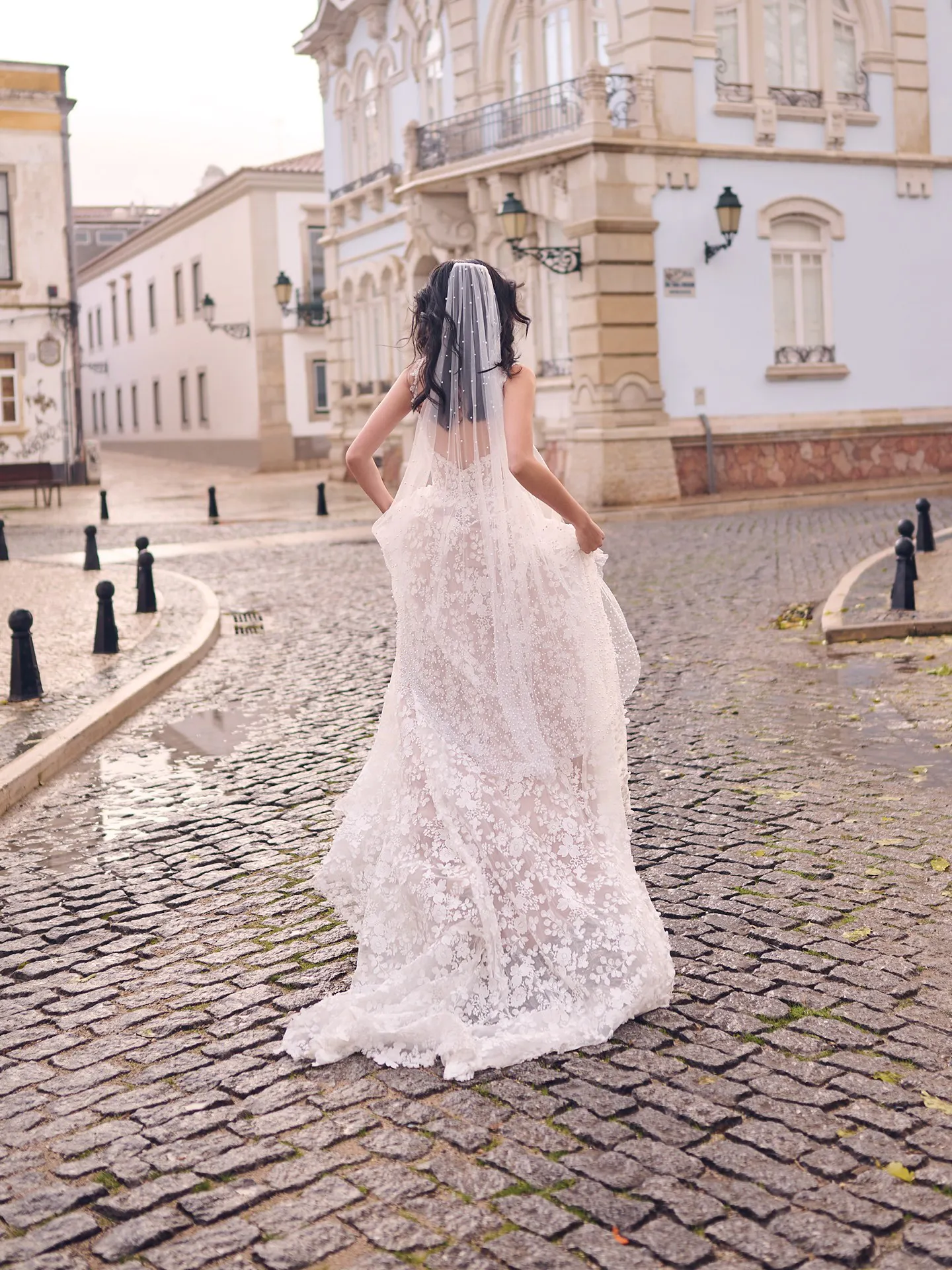 Maggie Sottero Ladonna back view, 3D floral lace wedding dress in a cobblestone street setting