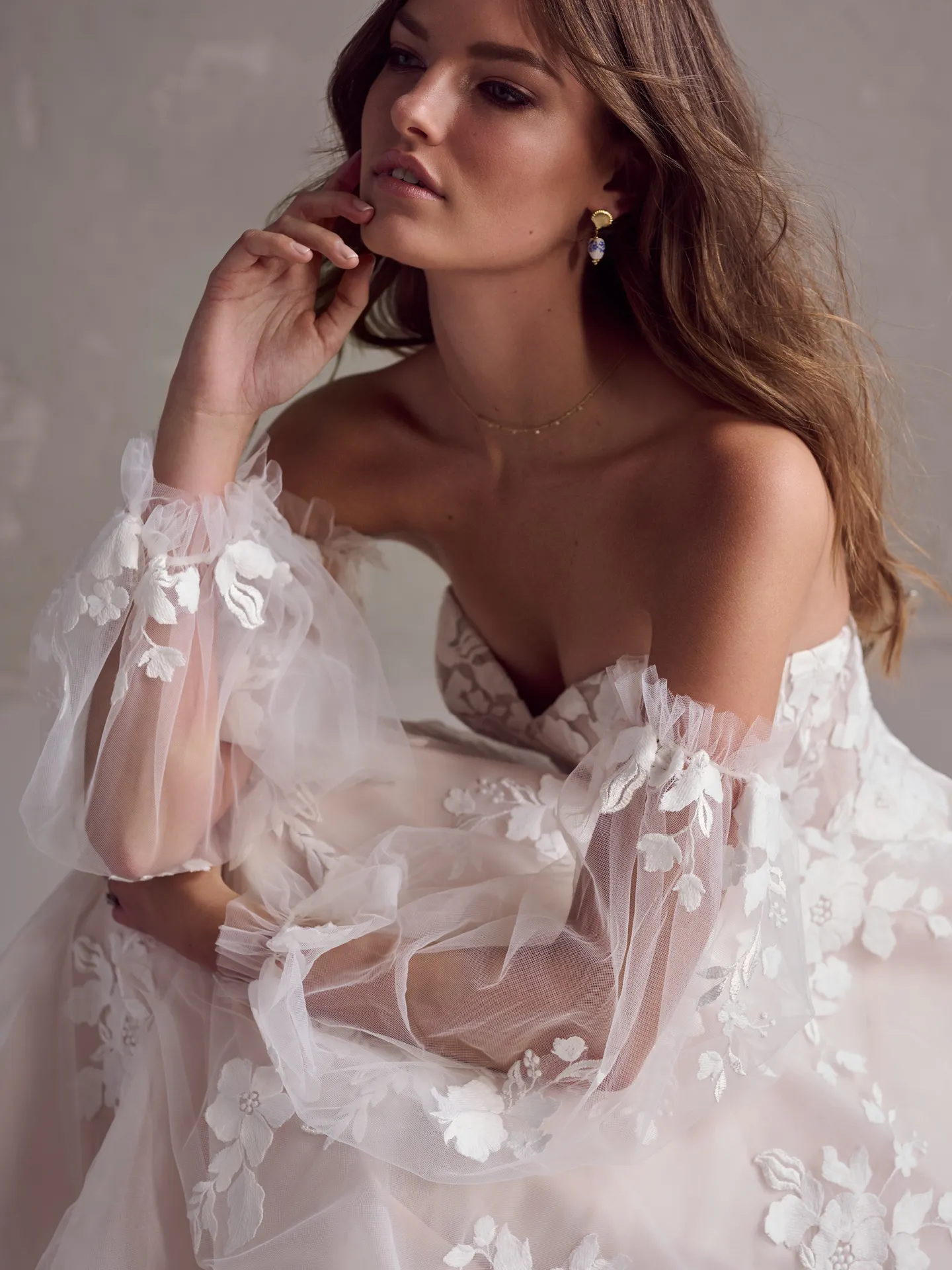 Rebecca Ingram Ruby A-Line gown with floral lace and sheer sleeves.