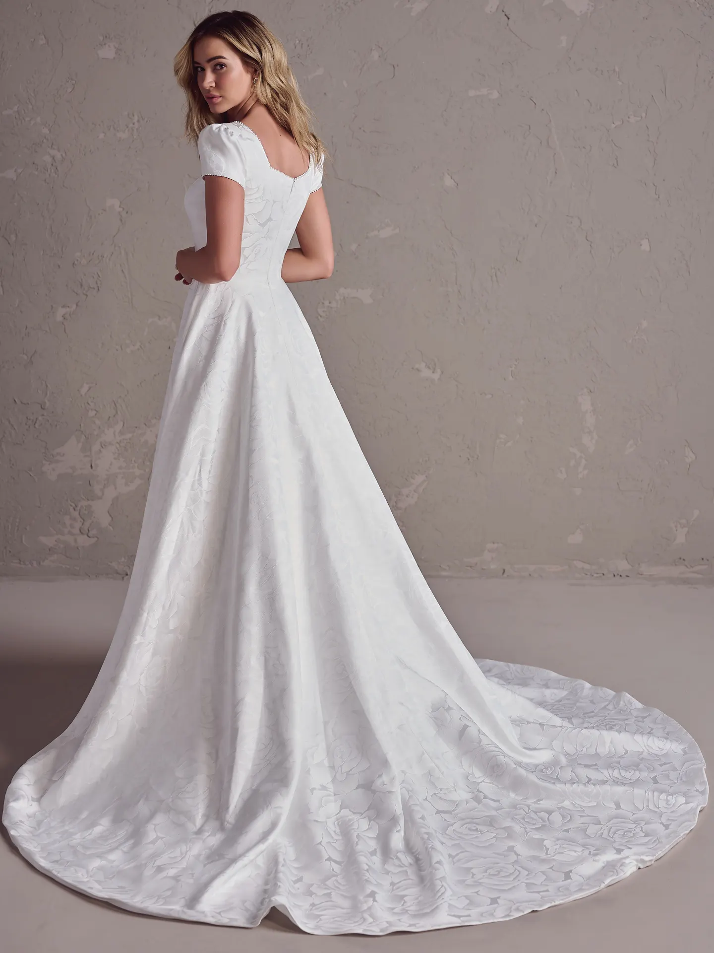 Rebecca Ingram Vesta Leigh back view, short sleeves, textured A-line bridal gown.