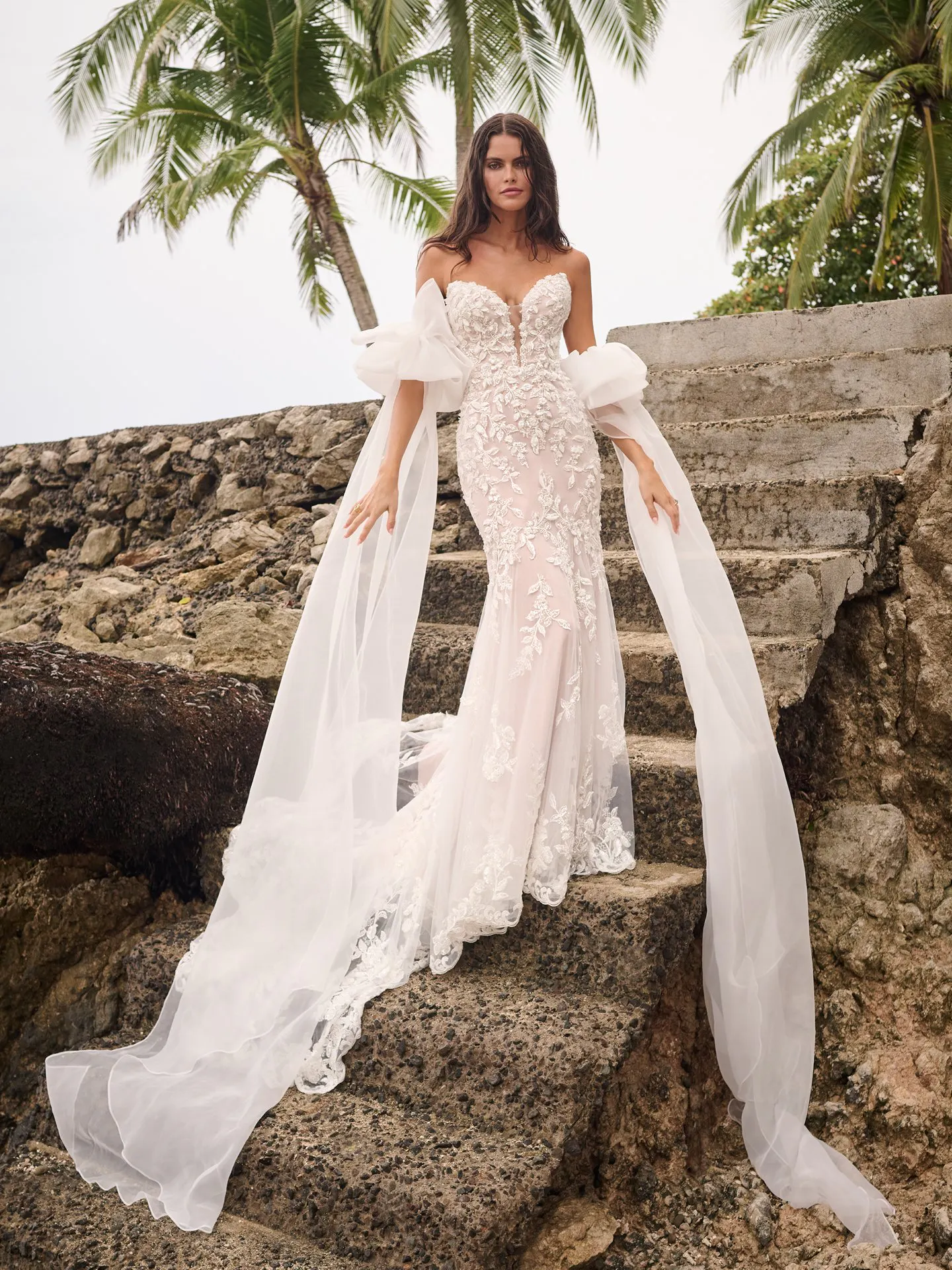 Sottero and Midgley Tanica front view shot on stone steps with a tropical background.