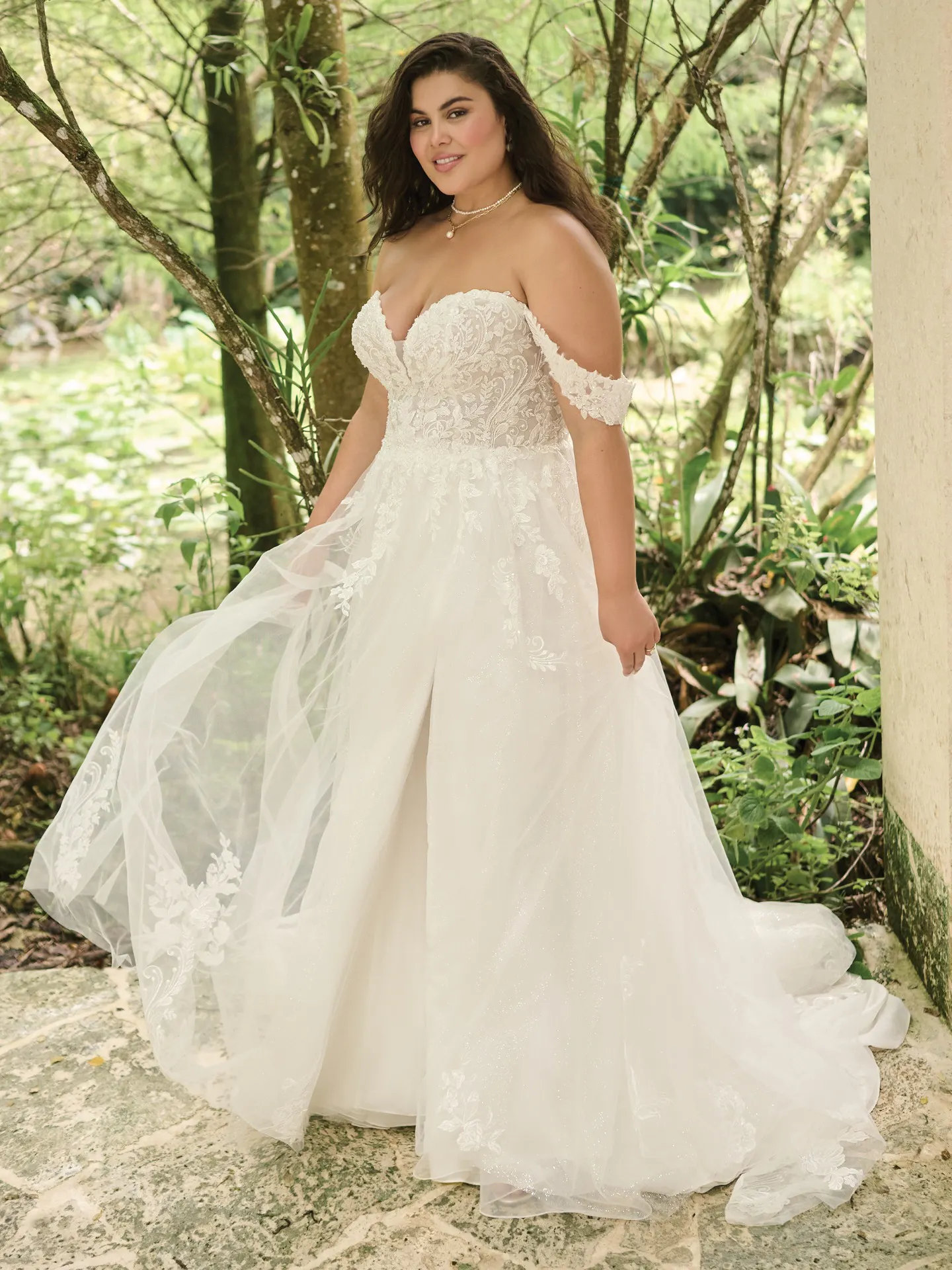 Maggie Sottero Marguerite front view in a garden wearing an A-line bridal gown with slit