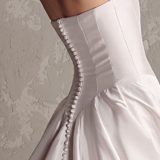 Maggie Sottero Emmanuelle side view showing strapless, yarn-dyed bodice with buttons