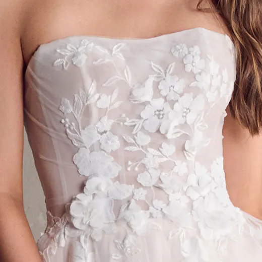 Maggie Sottero Laila floral gown close-up showing detailed 3D floral embroidery on bodice.