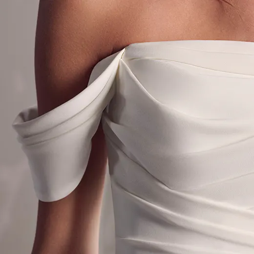 Maggie Sottero summer crepe wedding dress, off-shoulder detail, front view.