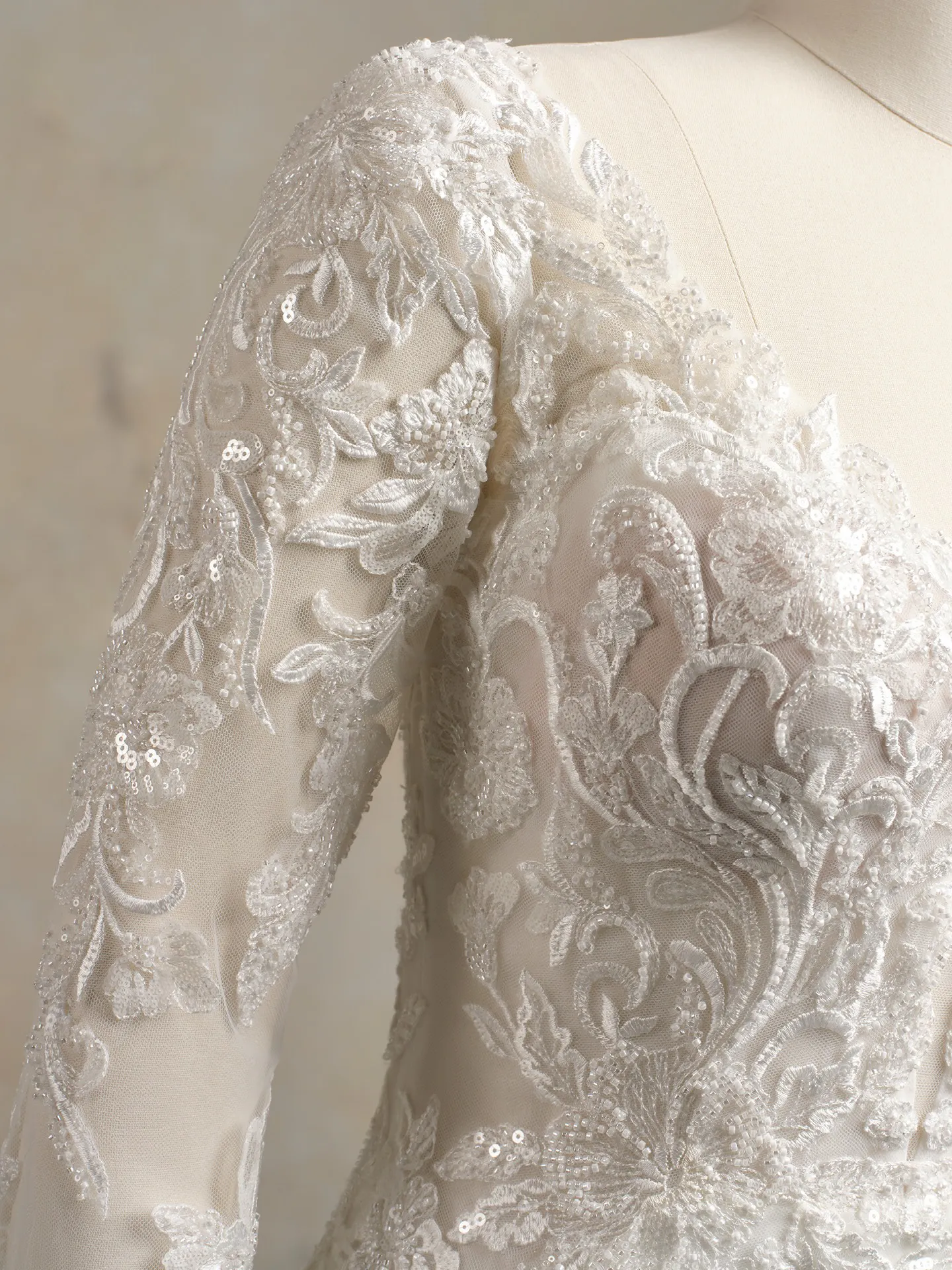 Anastasia stretch crepe beaded bridal gown, close-up of lace and sequin detail on sleeve.