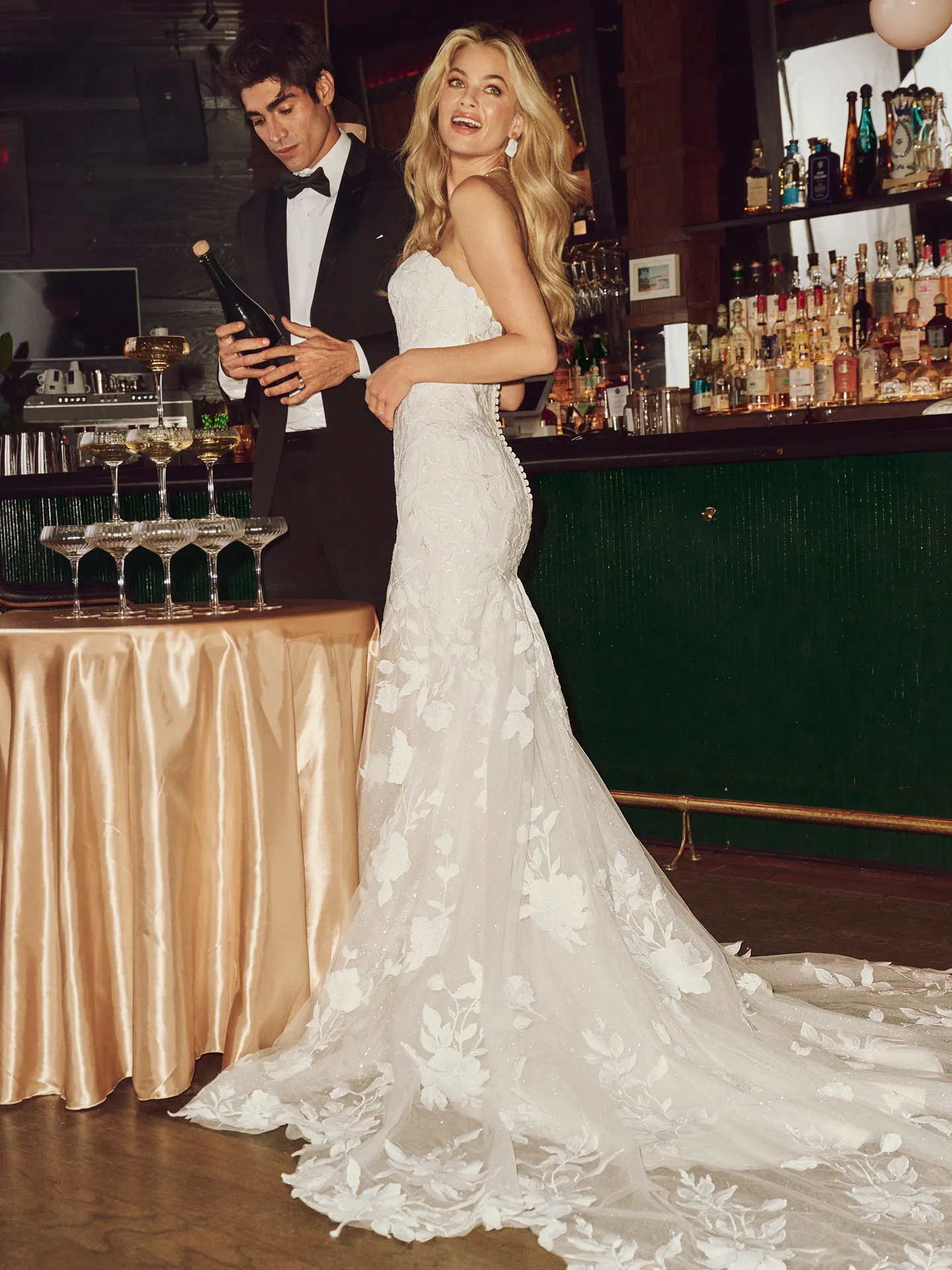 Maggie Sottero Bridget floral lace wedding dress back view near bar setting.