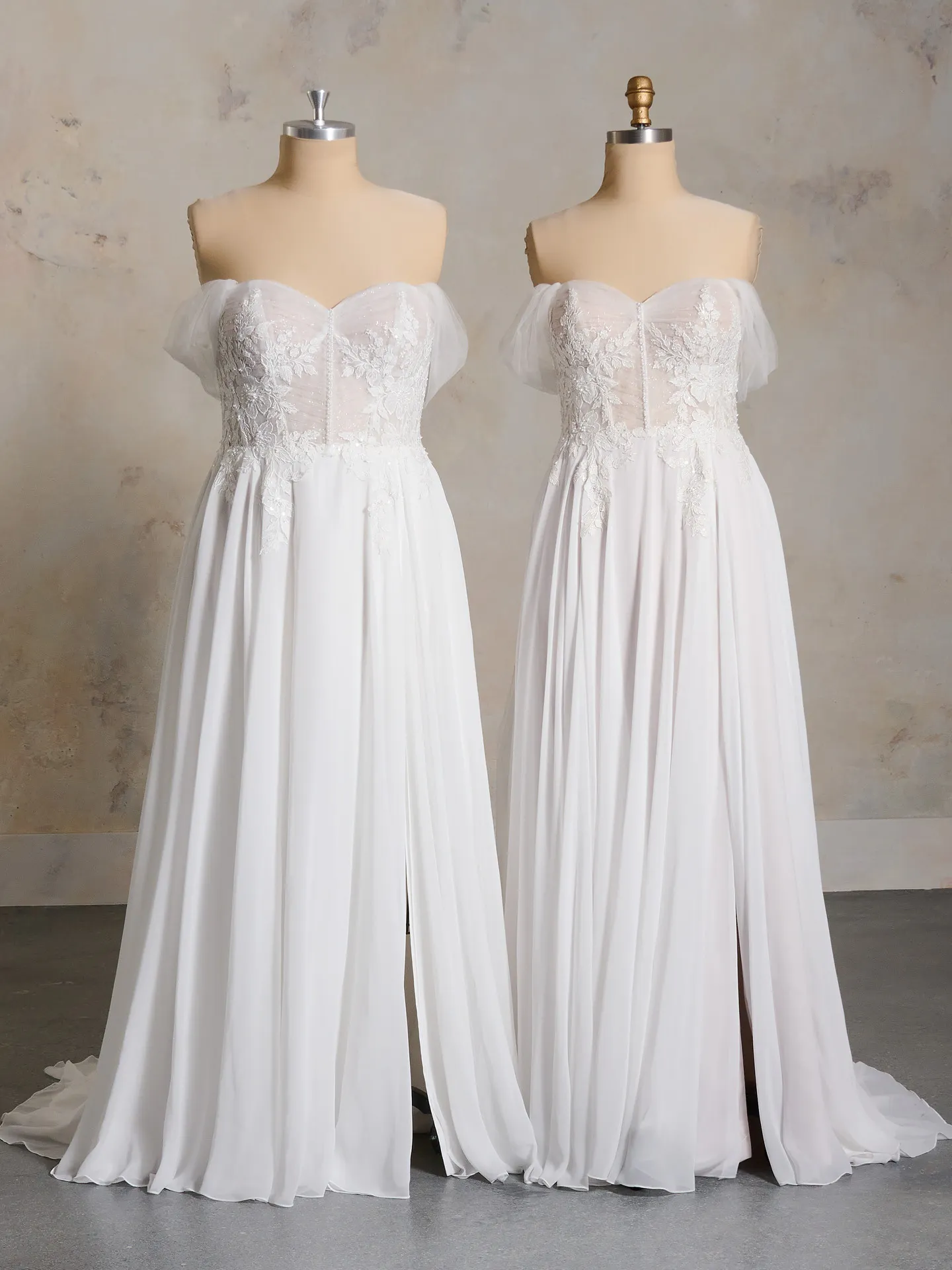 Blake flowy tulle wedding dress with corset and pearls on mannequins, front view.