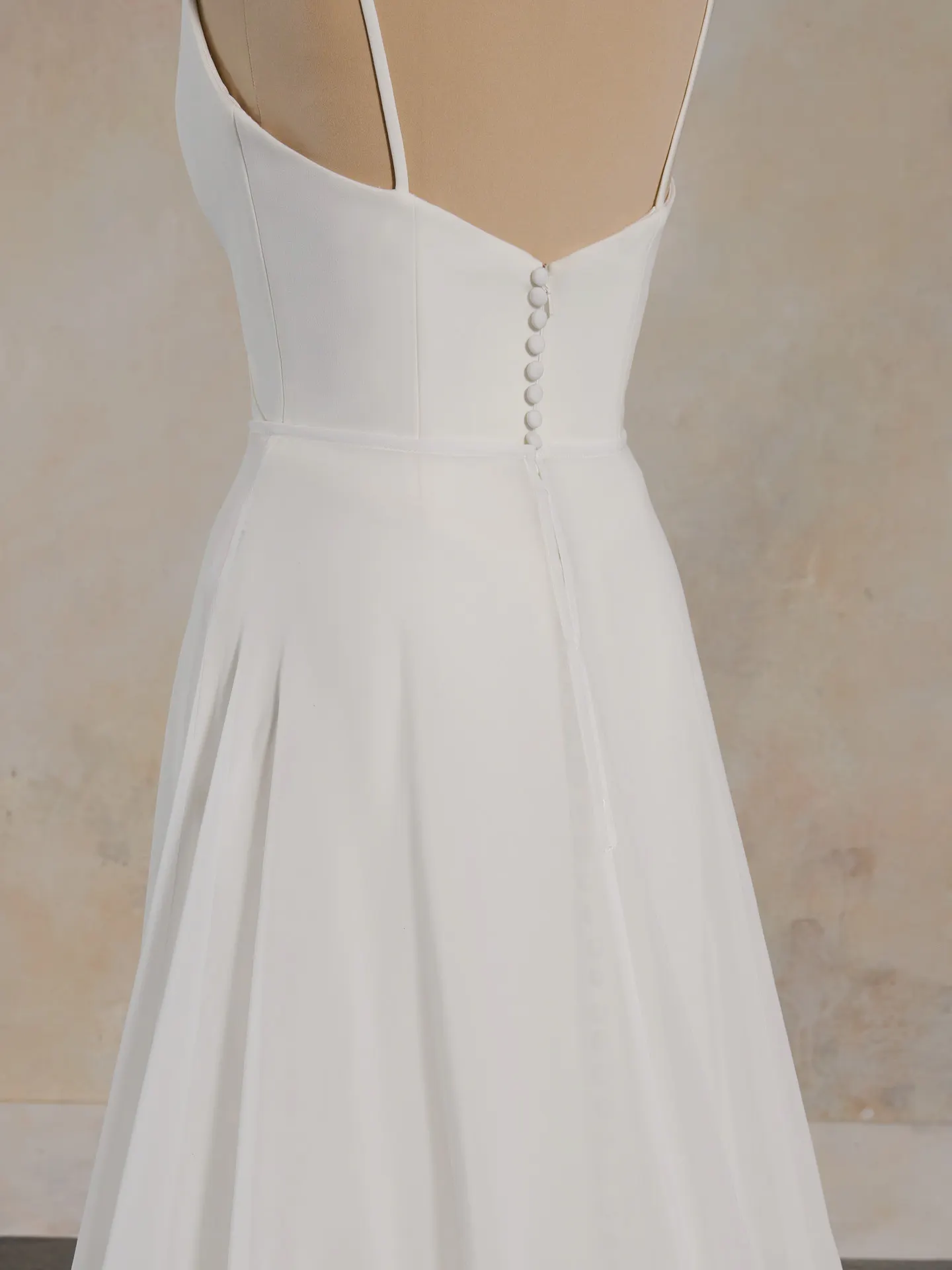 Maggie Sottero wedding dress back view with buttons and chiffon overskirt.