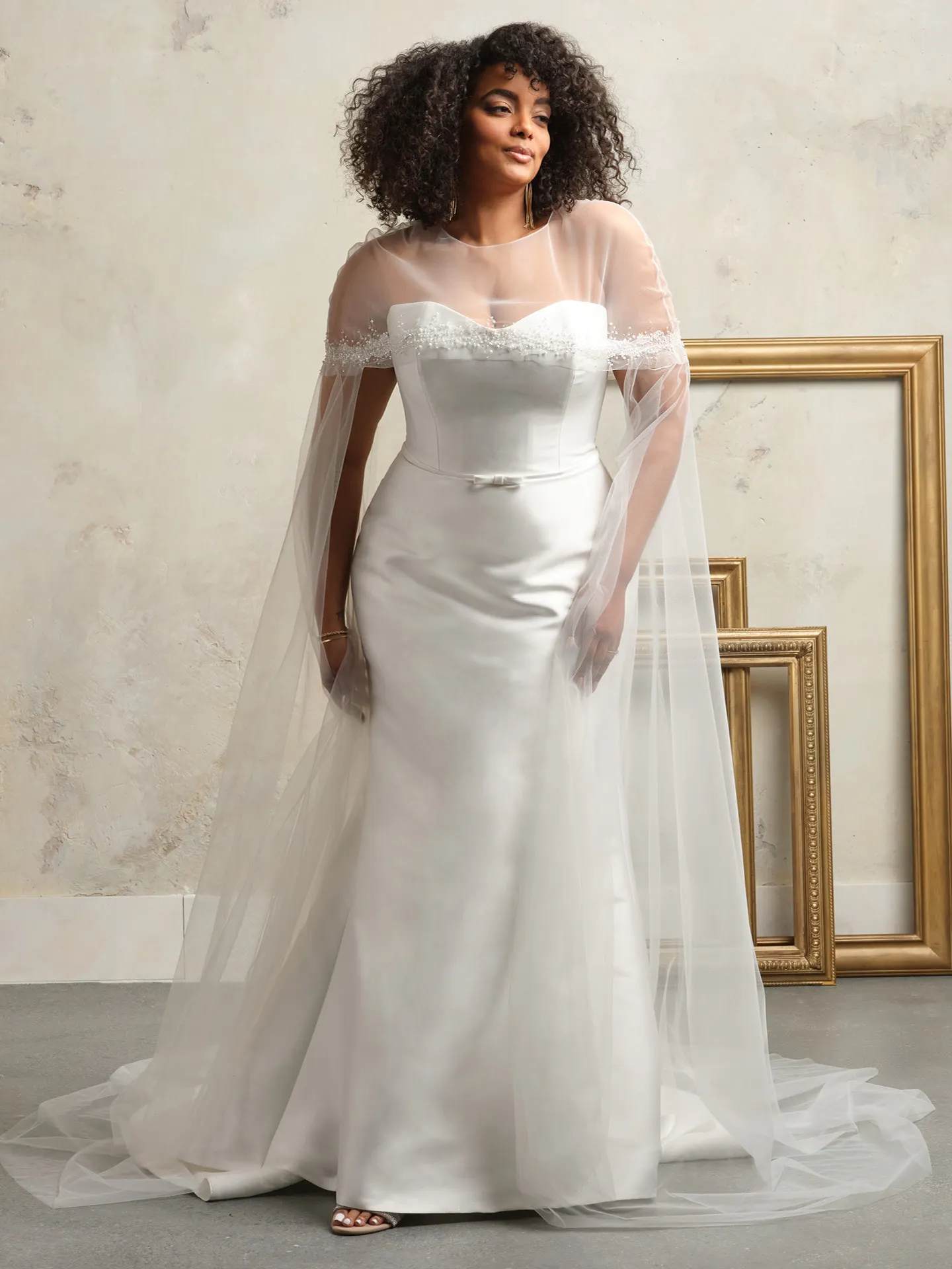 Maggie Sottero Maisie front view wedding gown with bow and sheer overlay.
