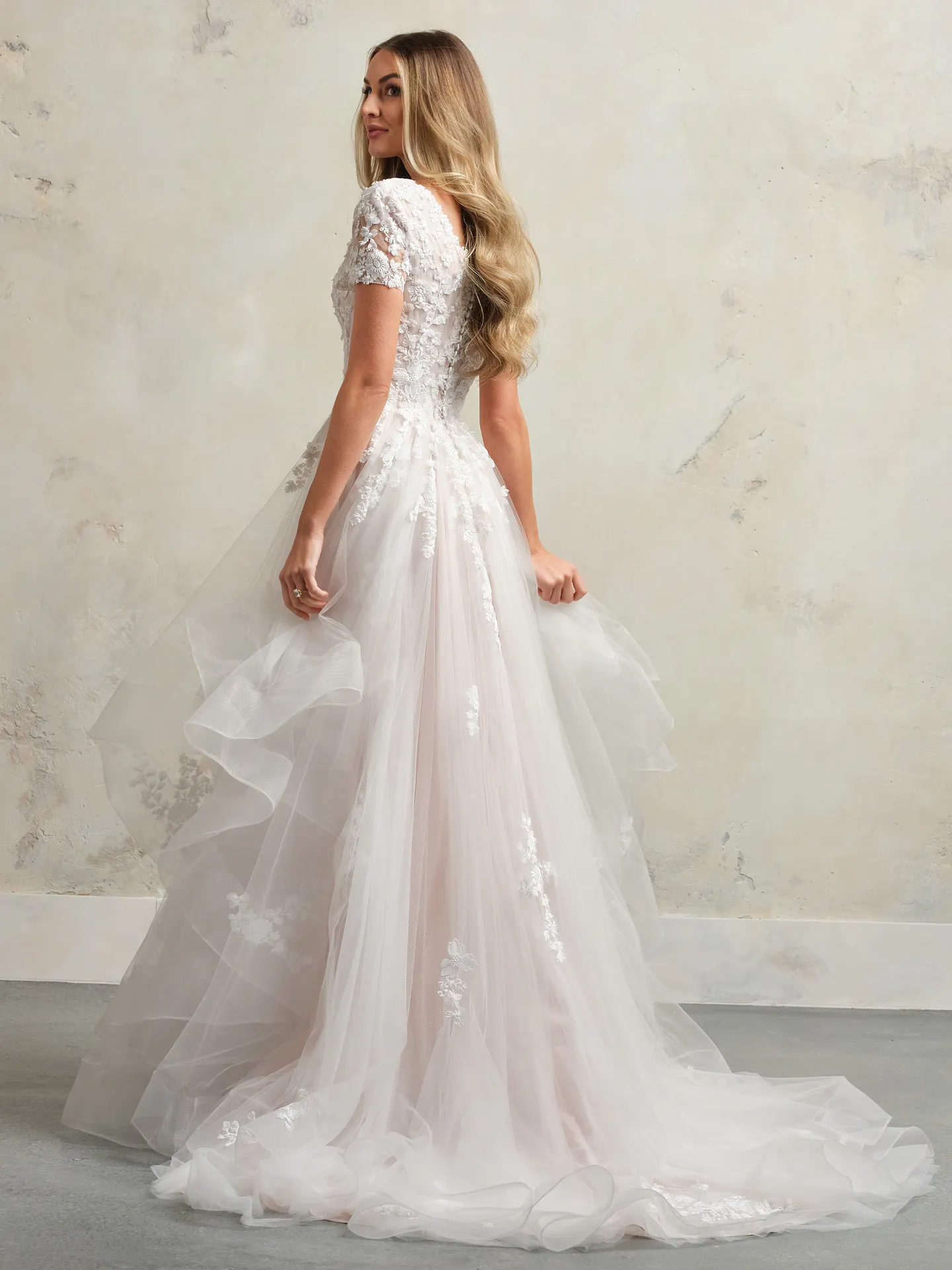 Winona Leigh floral ball gown back view with lace and tulle layers.