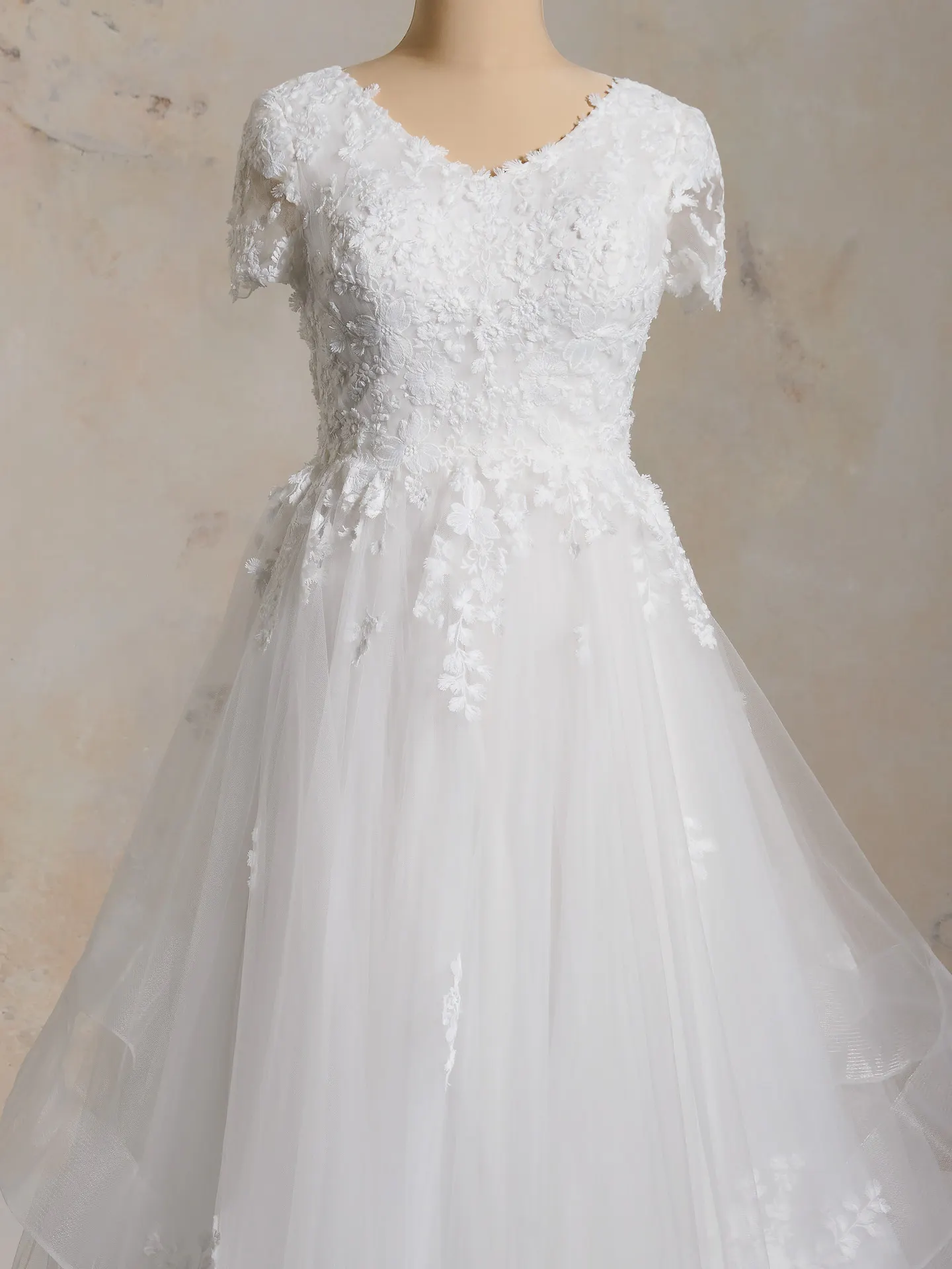 Winona Leigh floral ball gown front view with lace and tulle on mannequin.
