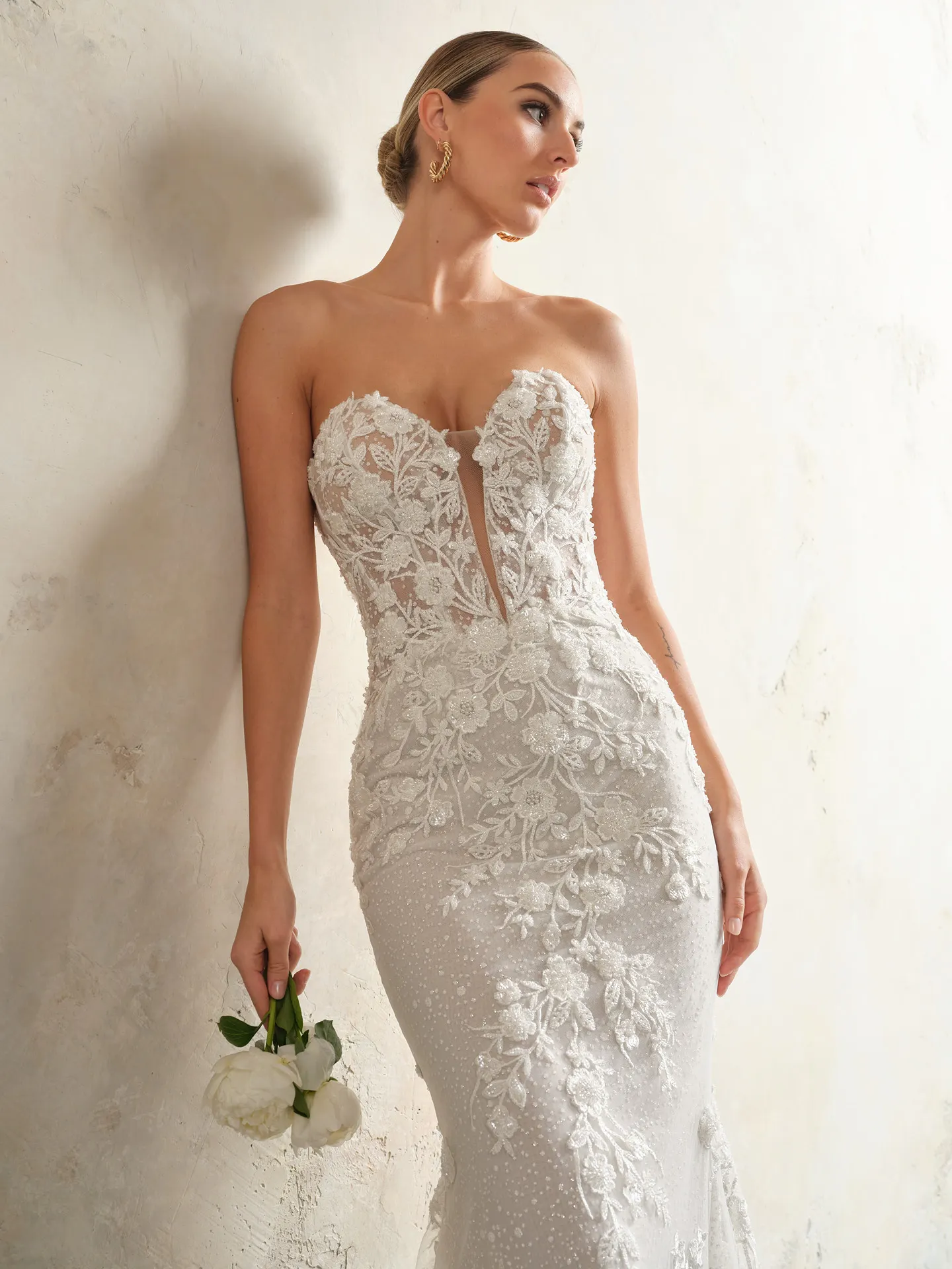 Chesney illusion sweetheart dress front view, floral lace detail, holding flowers.