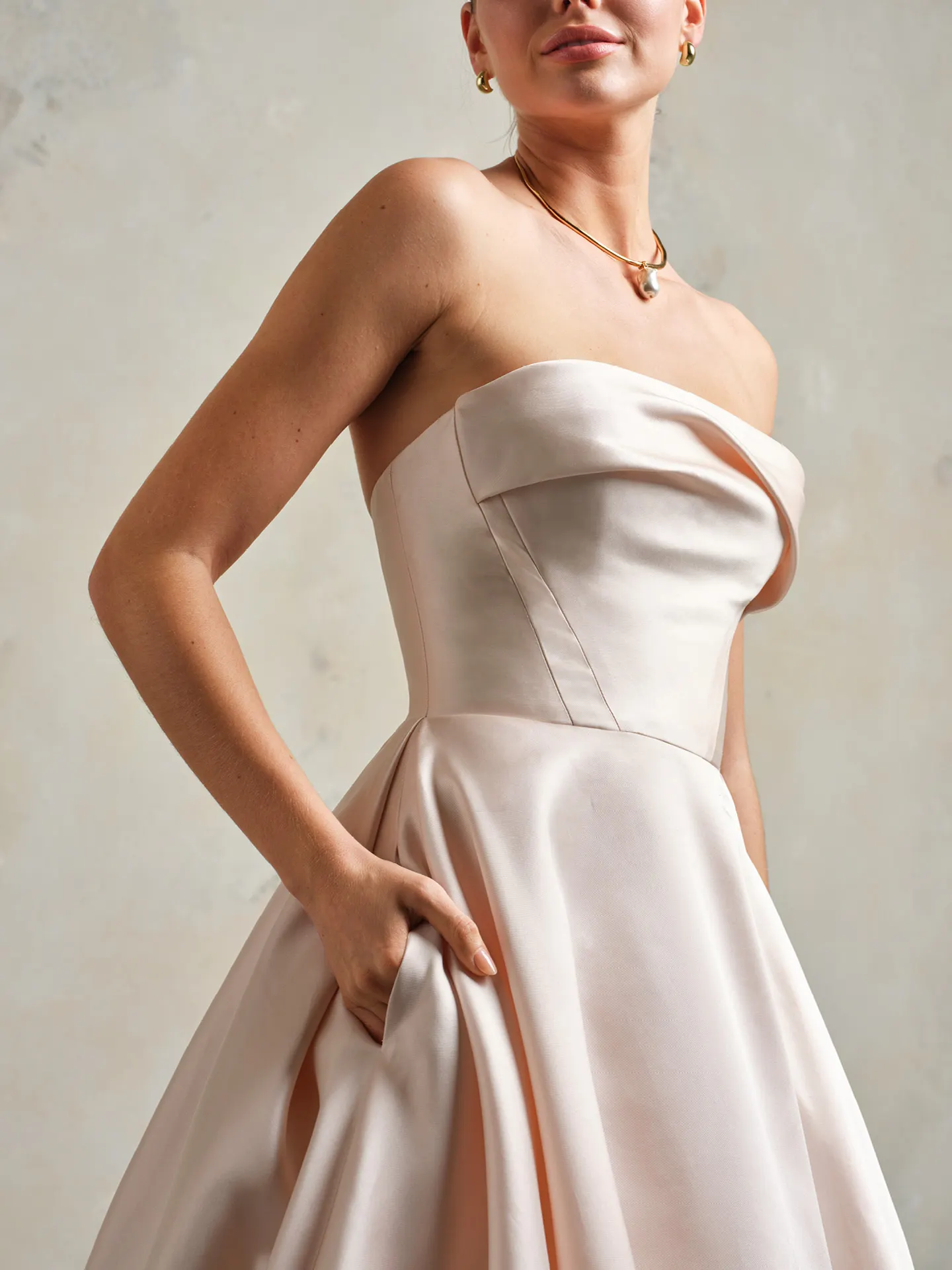 Strapless Mikado bridal gown side view with draped bodice and full skirt.
