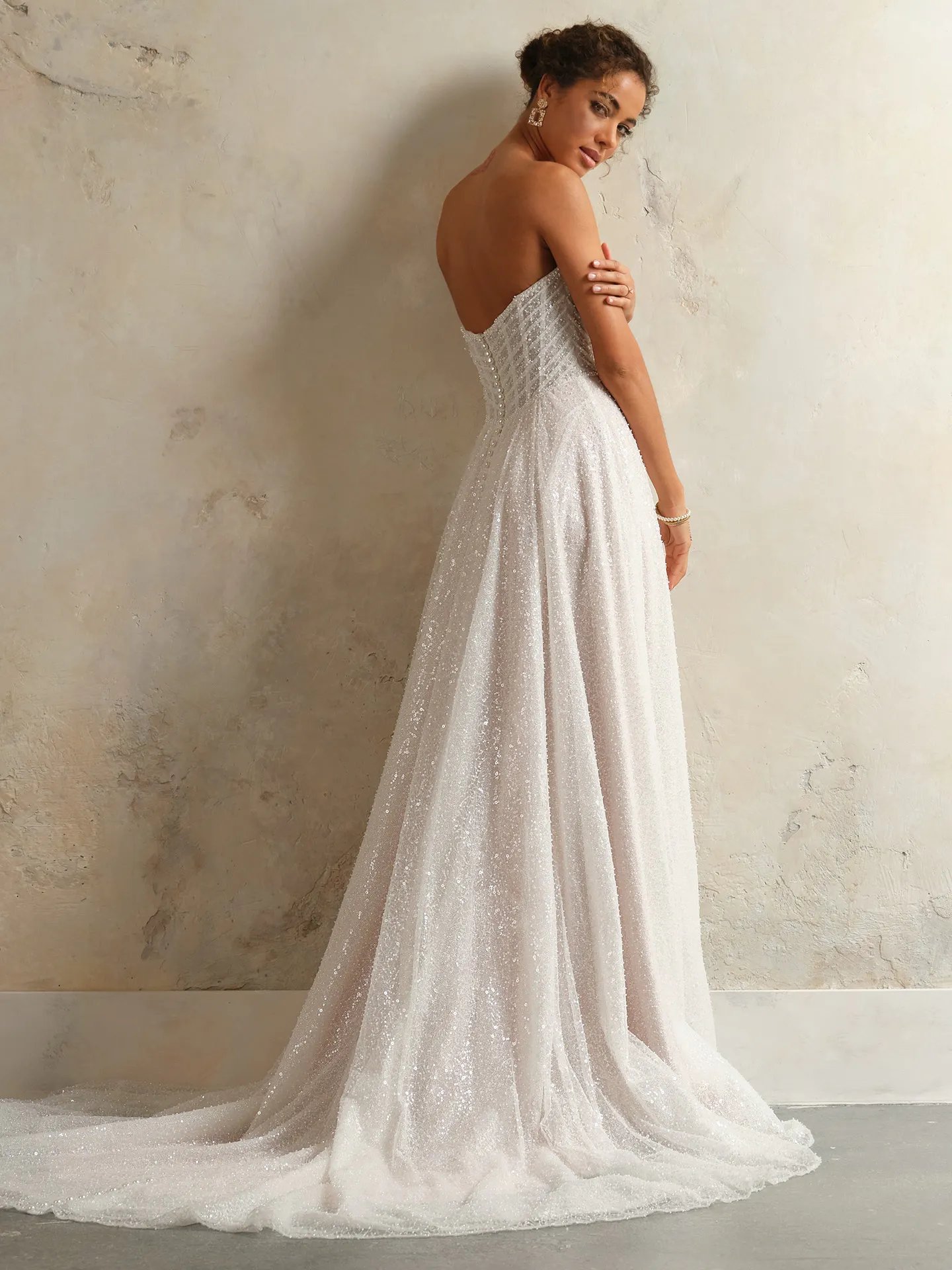 Monica gown side view, off-the-shoulder bridal dress with shimmering fabric.