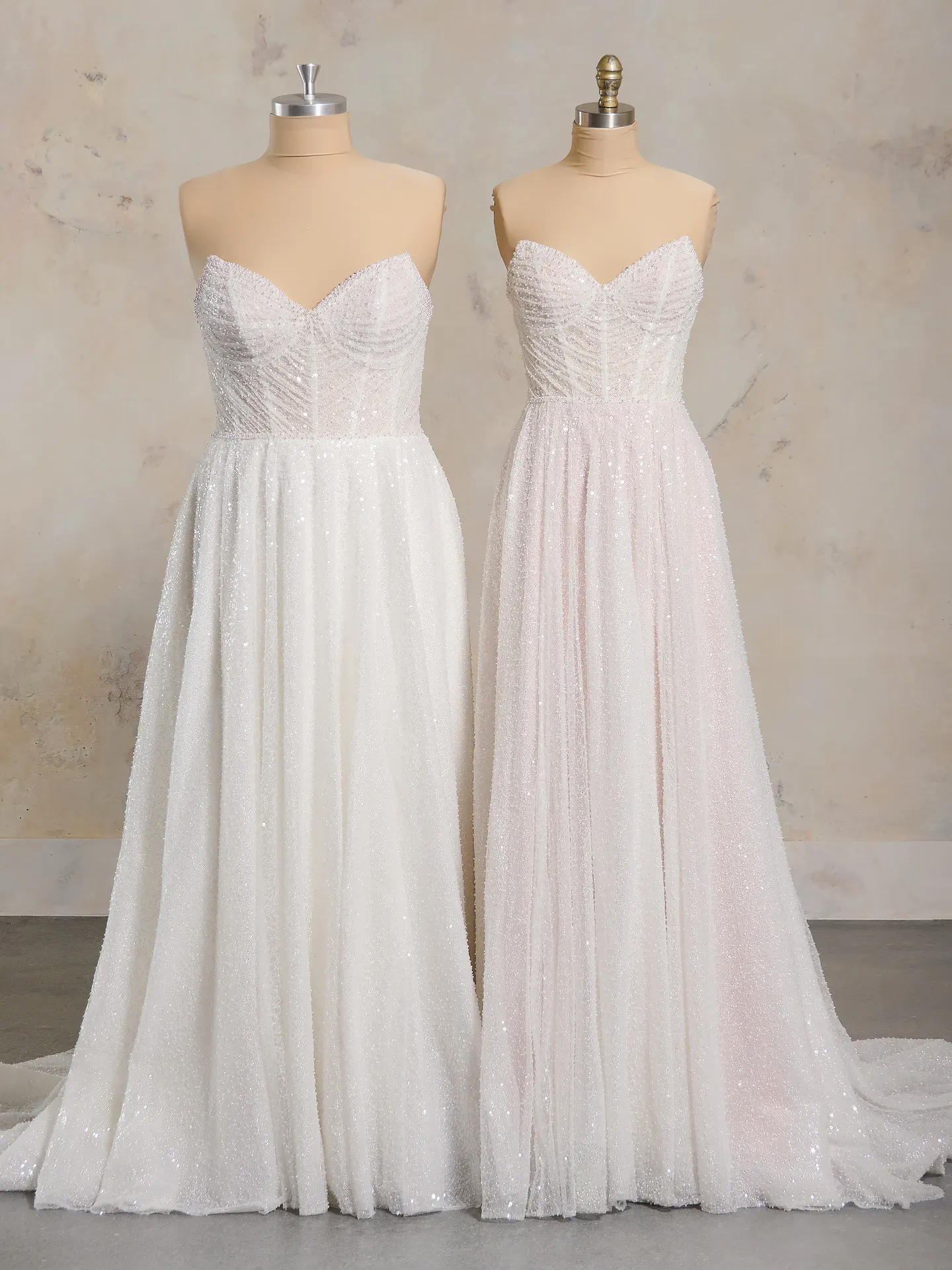 Maggie Sottero Monica front view on mannequins, sparkly A-line with sweetheart neckline.