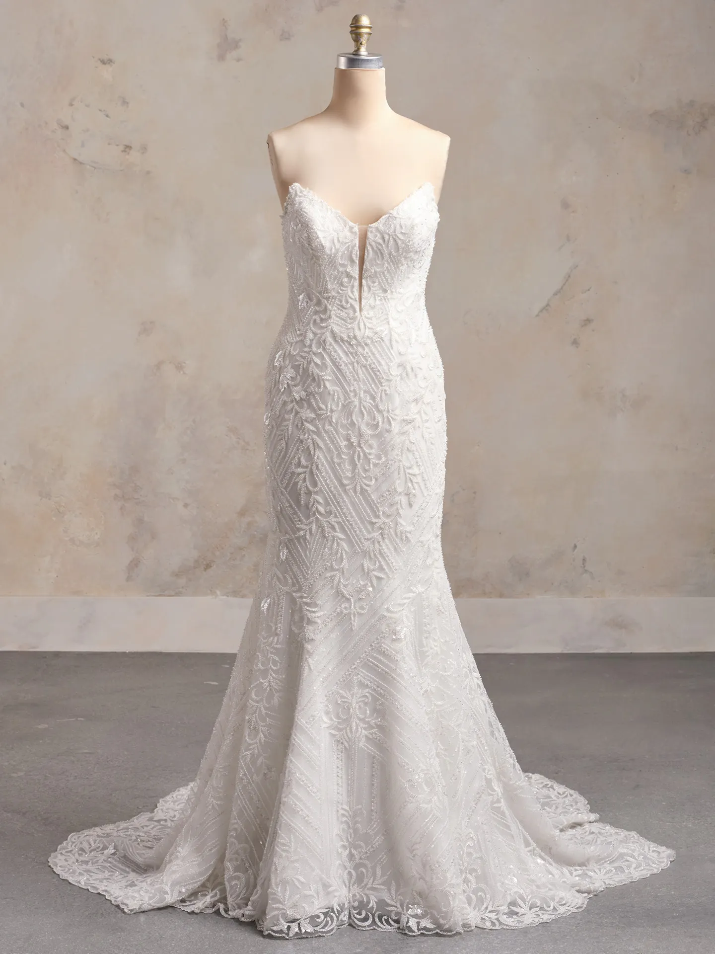 Beaded Sorrento strapless gown on mannequin in front view, ornate lace pattern.