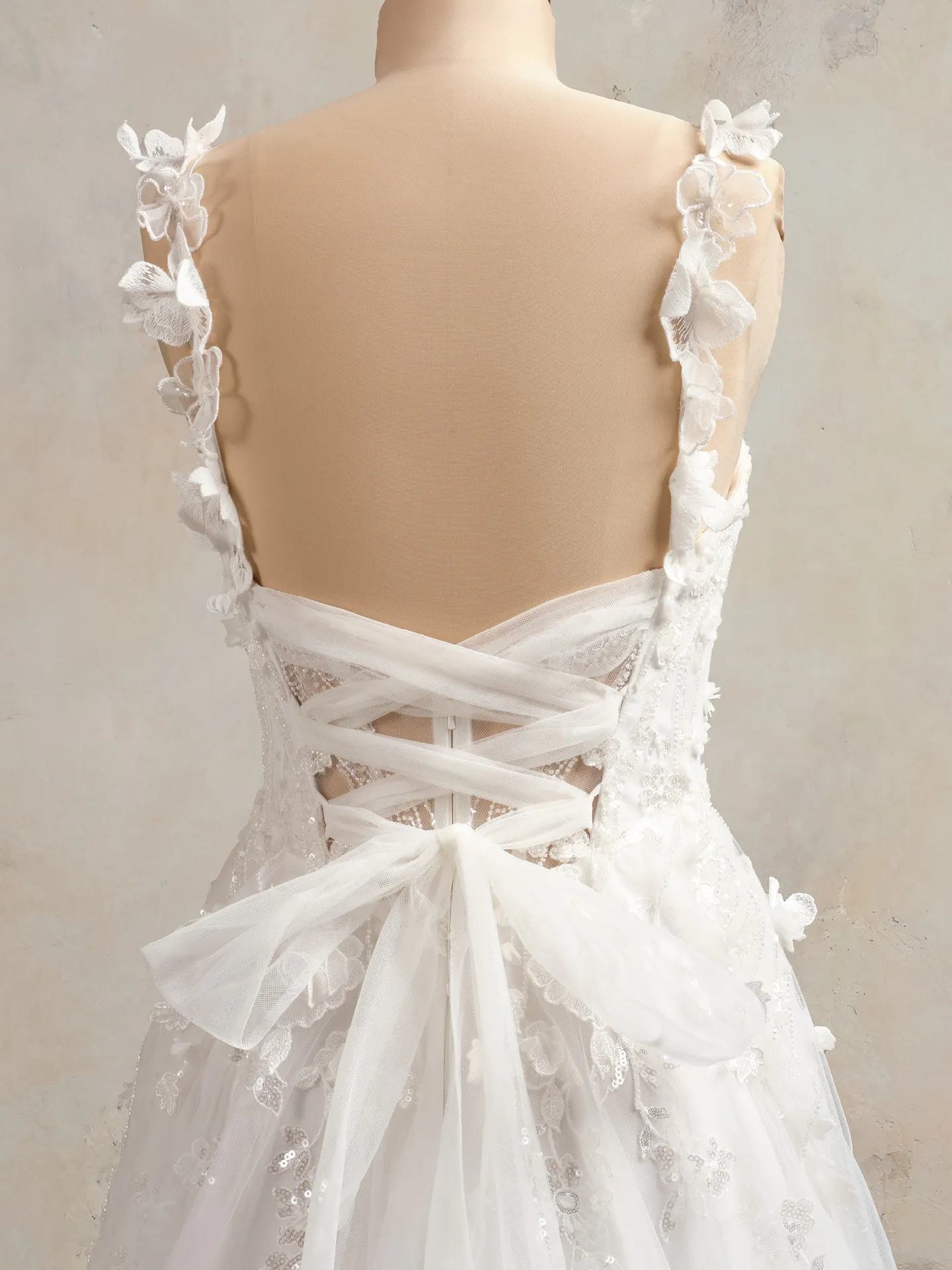 Maggie Sottero floral bridal dress back view with lace-up detail and 3D accents.