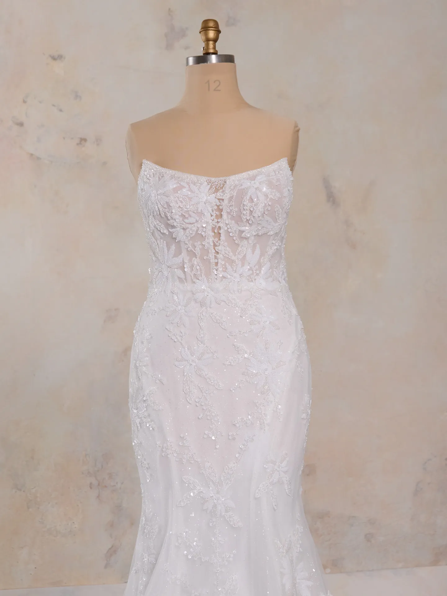 Sheer strapless Madrona lace corset wedding dress on mannequin, front view.