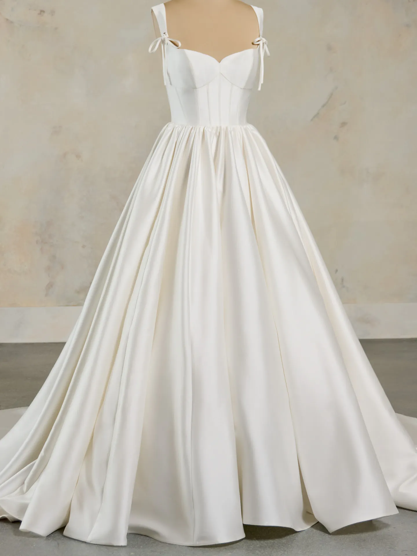 Maggie Sottero Talitha front view A-line wedding dress with straps and ruffled bow.