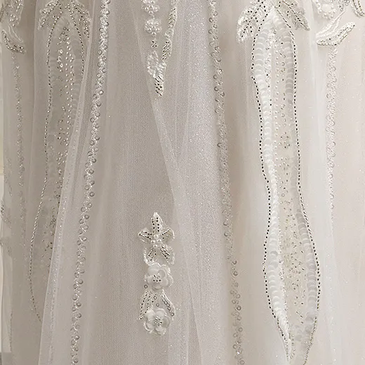 Maggie Sottero Edie glittering gown detail view with intricate beadwork.
