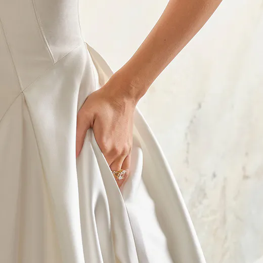 Rebecca Ingram bridal dress detail with hand holding satin fabric.