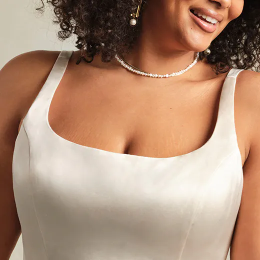 Selena satin gown front view; elegant neckline and pearl necklace shown.