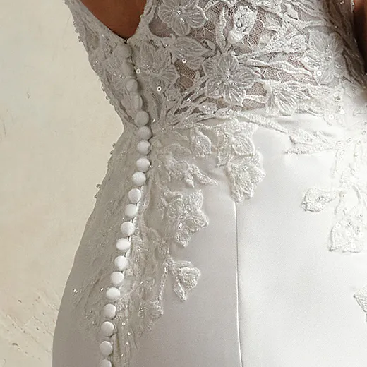 Maggie Sottero fit-and-flare dress side view with lace and button details.