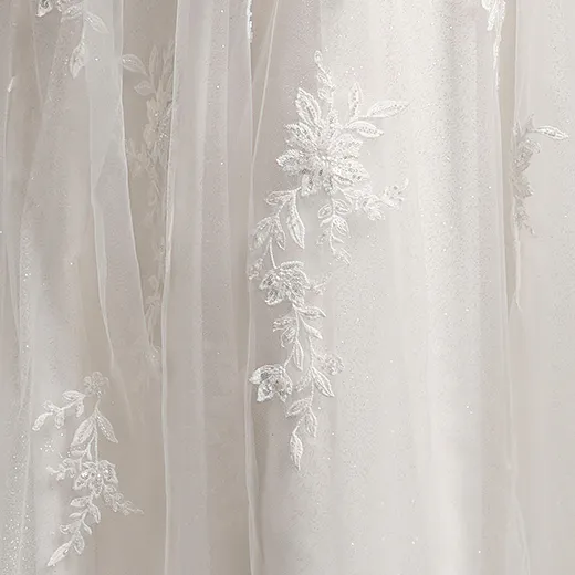 Catherine bridal dress detail with floral lace embroidery on fabric.