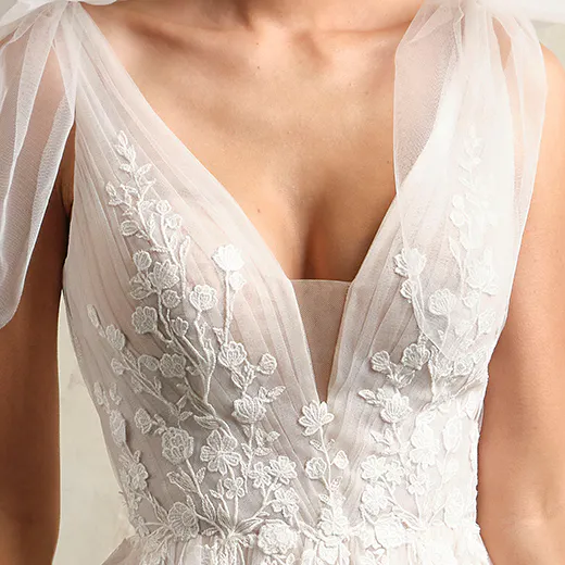 Maggie Sottero Zinnia lace V-neck gown close-up with floral embroidery.