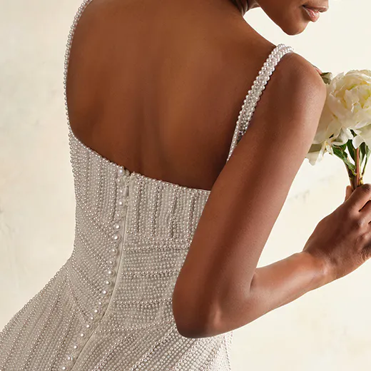 Maggie Sottero Danica back view pearl wedding gown with floral bouquet