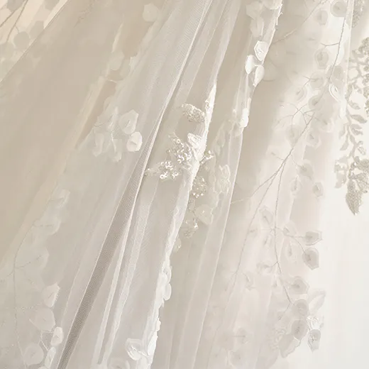 Delicate floral tulle wedding gown with crisscross detail and intricate embroidery.