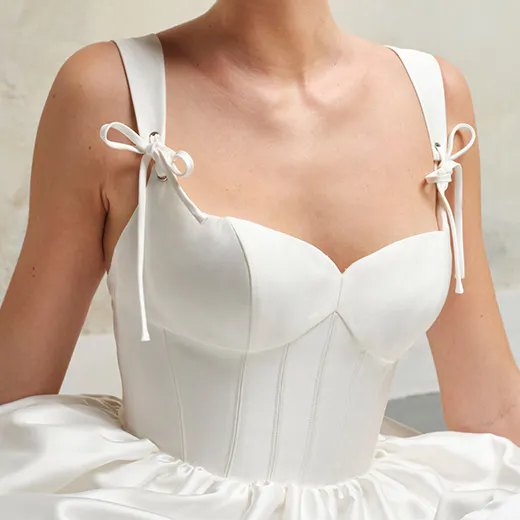 Maggie Sottero Talitha front view corset with ruffled straps and bow details.
