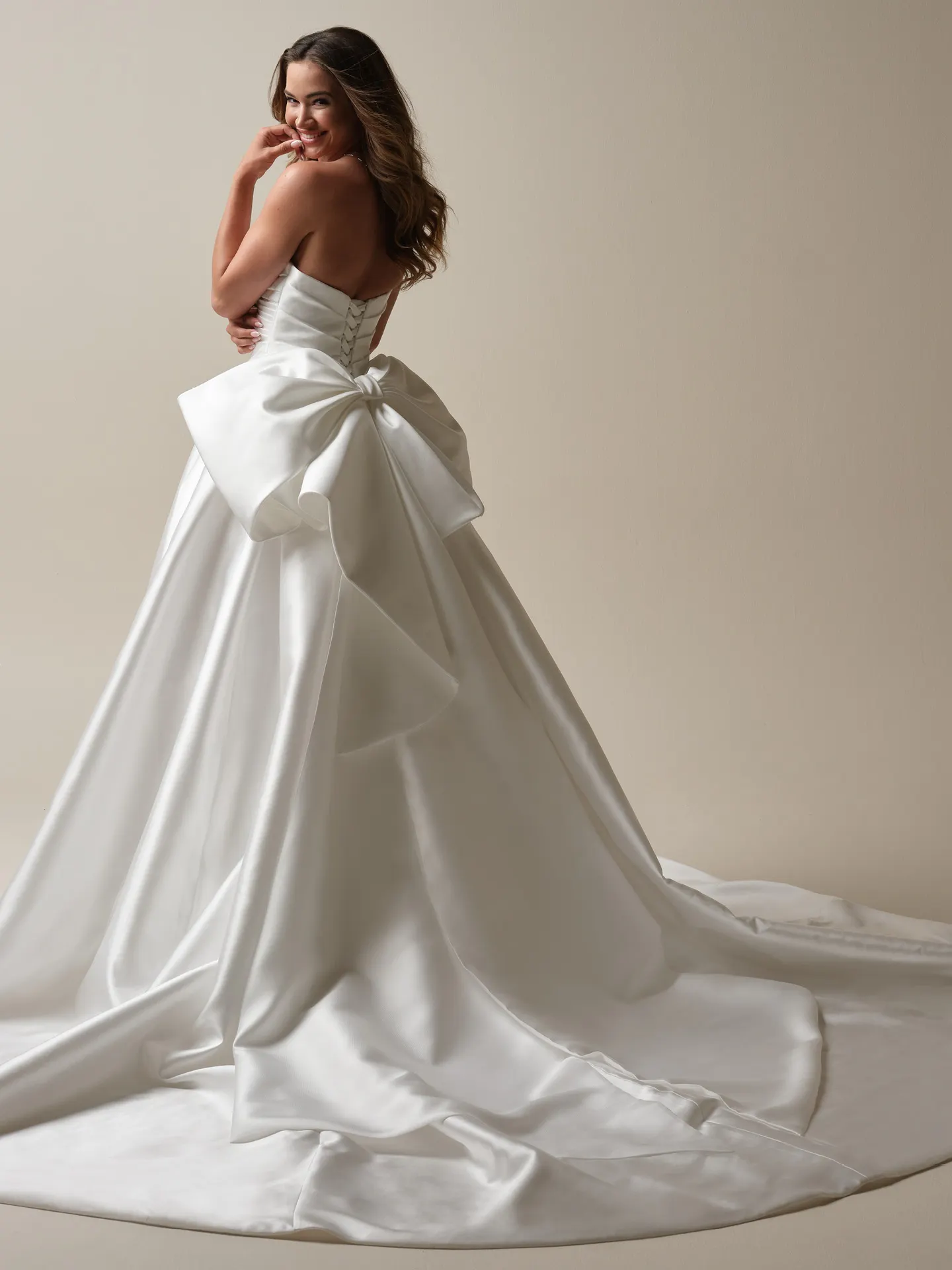 Aubrielle Marie back view, asymmetrical ball gown with large bow, Maggie Sottero.