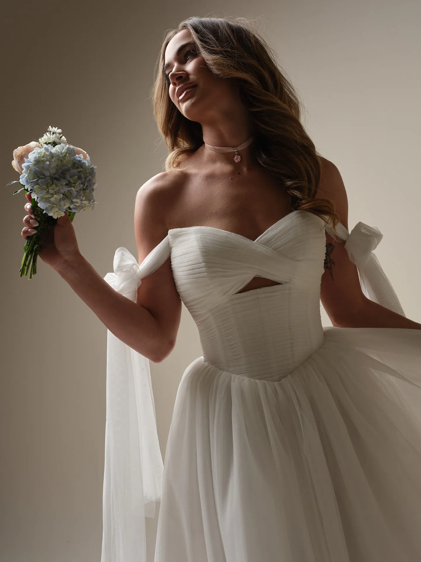 Maggie Sottero Evan front view pleated keyhole ball gown with bouquet