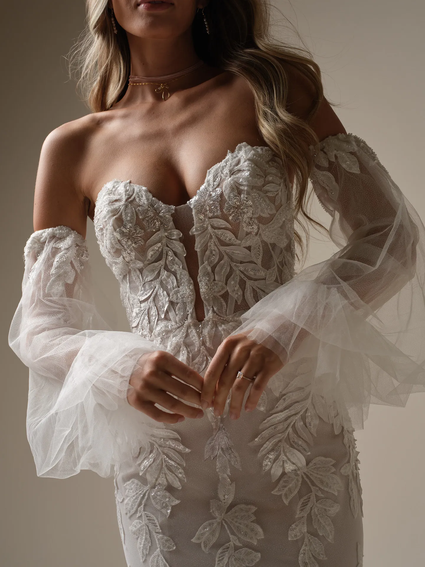 Maggie Sottero mermaid gown, leaf appliqué, sheer off-shoulder sleeves, front view.