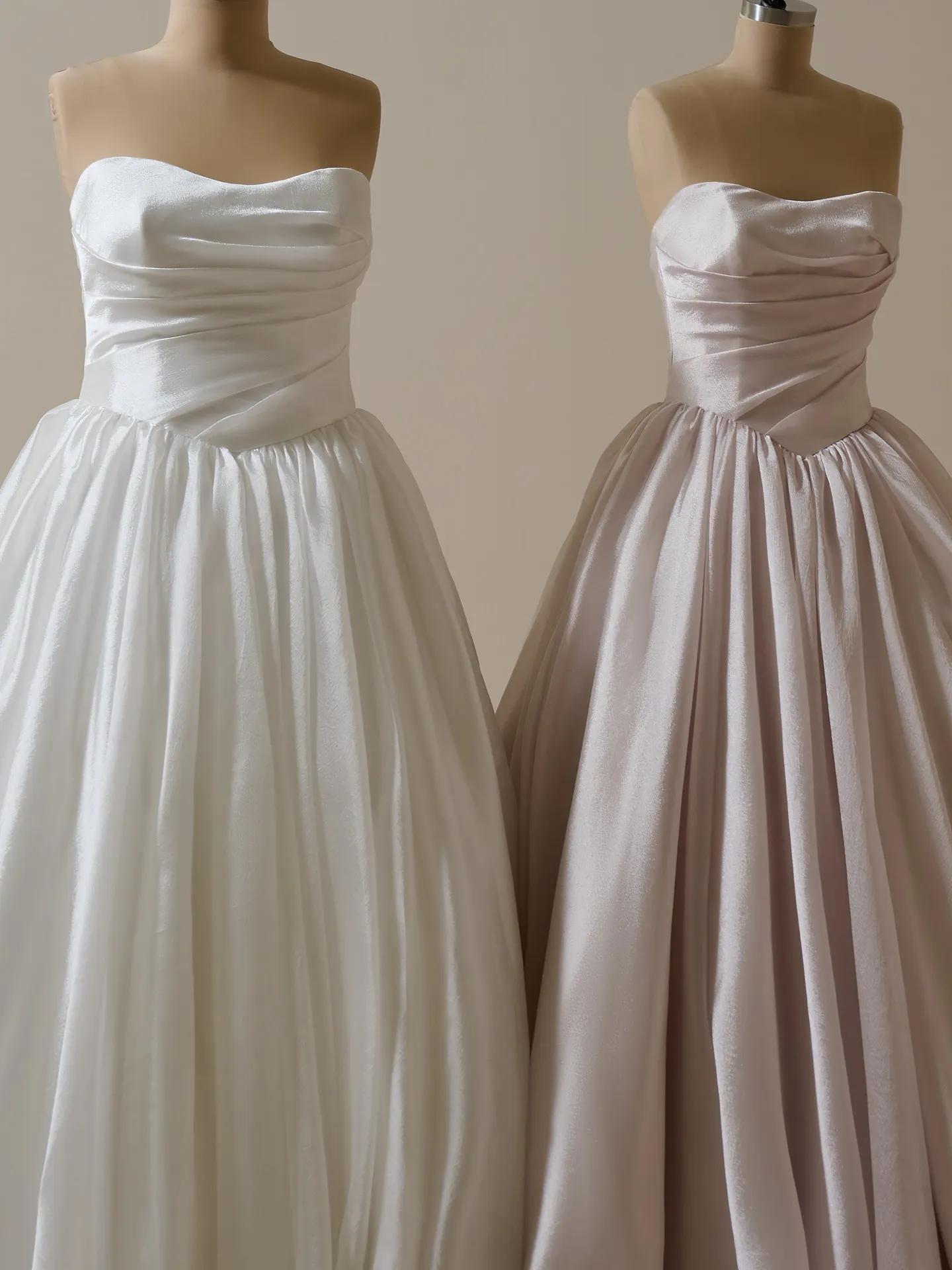 Maggie Sottero Paris asymmetrical basque waist dresses displayed side by side.