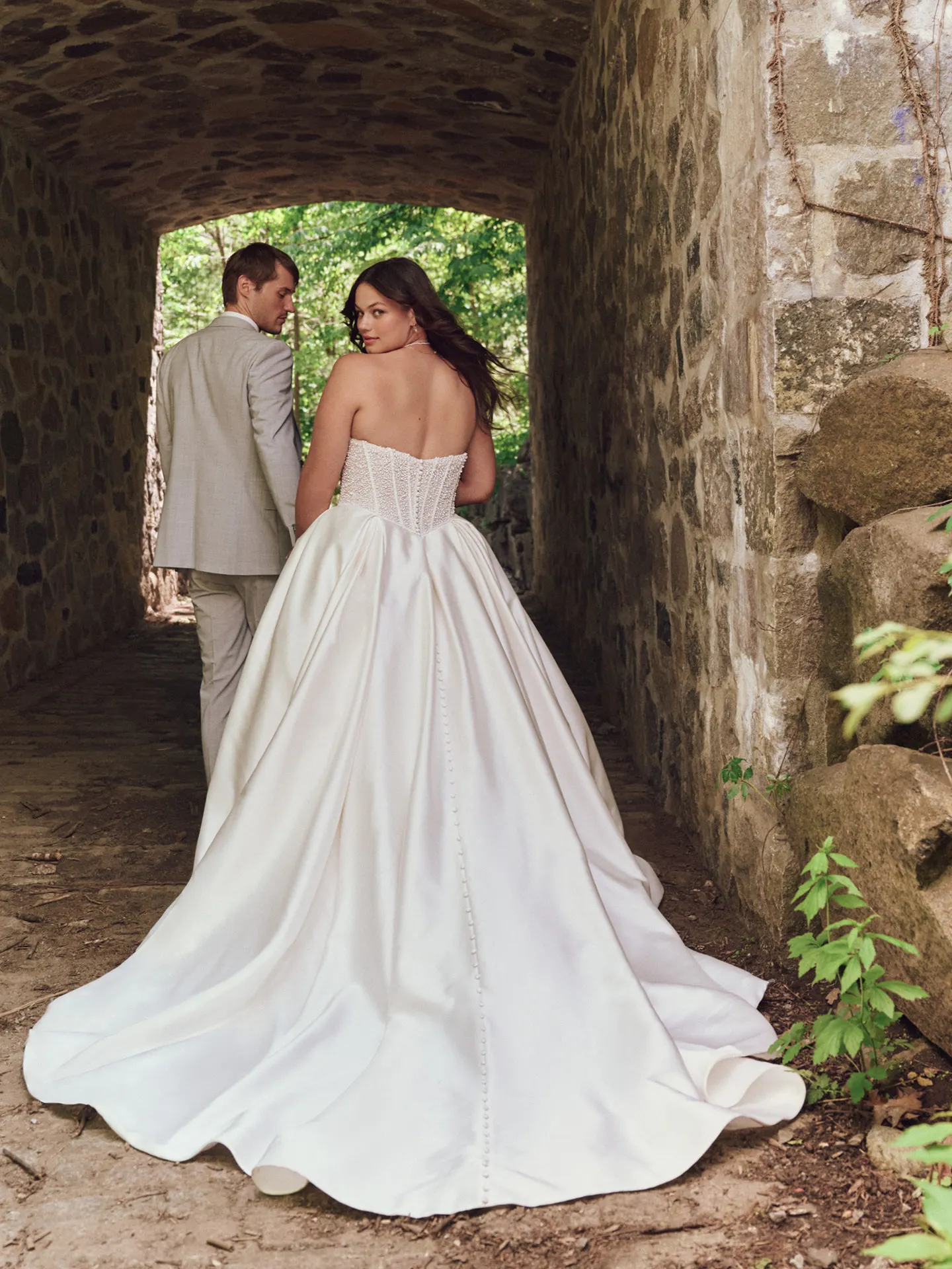 Tina Pearl ball gown back view in stone archway Maggie Sottero
